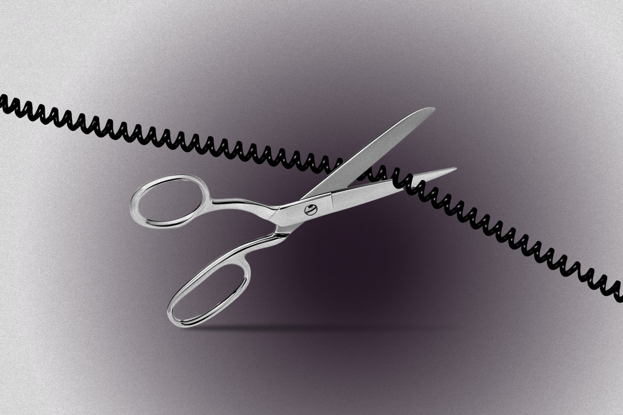 A pair of silver scissors is cutting through a black coiled telephone cord against a gray background.