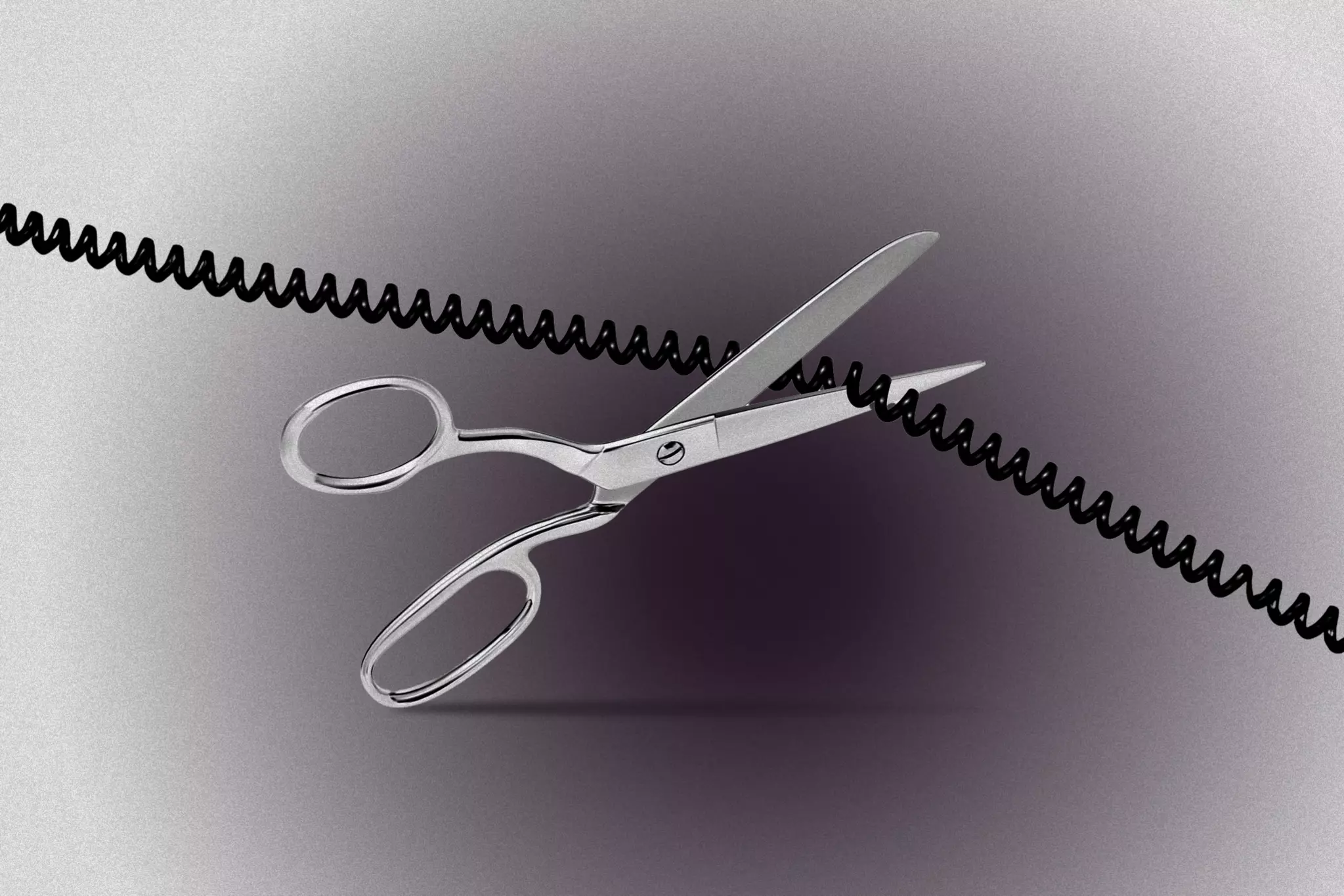 A pair of silver scissors is cutting through a black coiled telephone cord against a gray background.