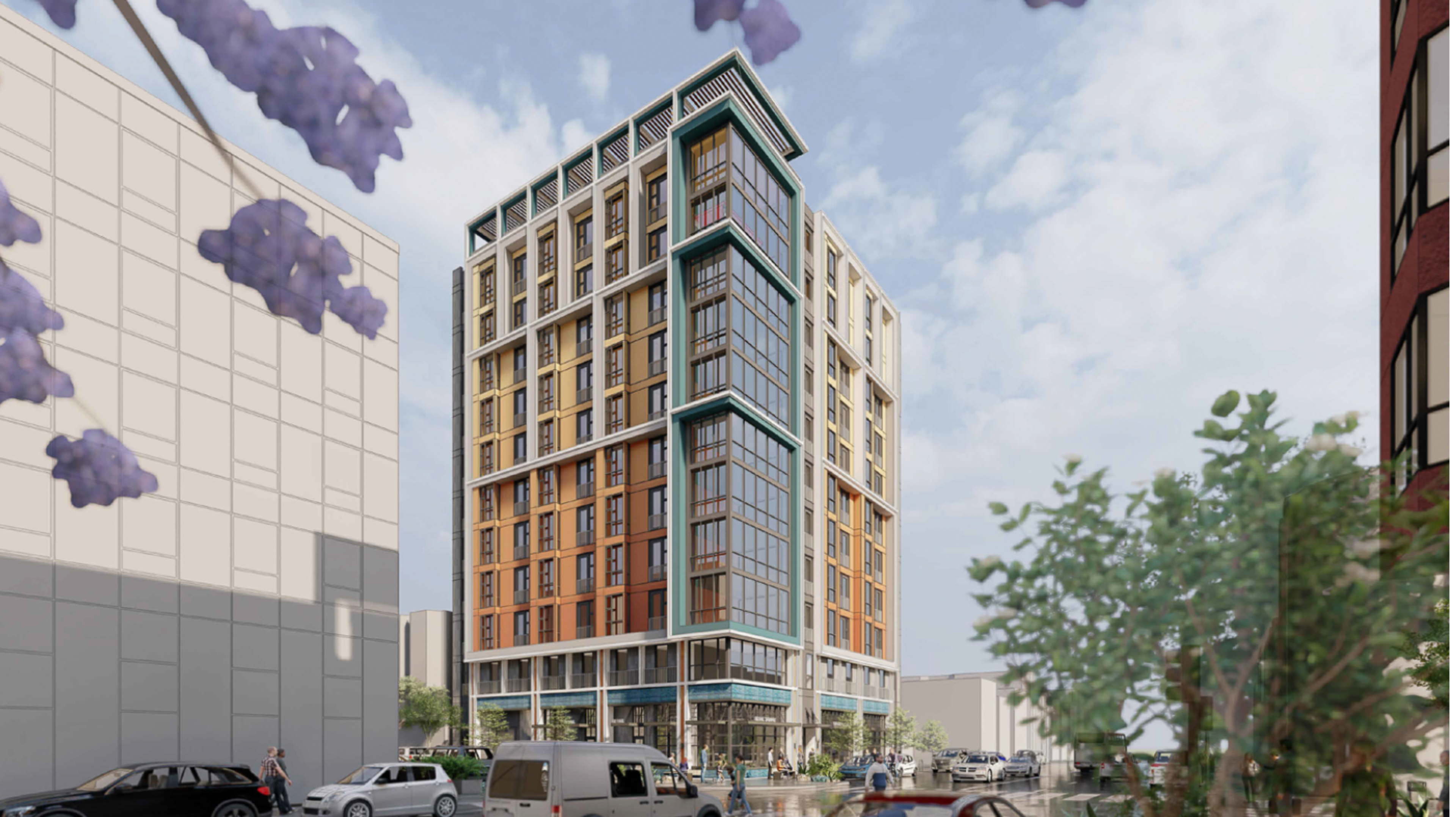 A modern, multi-story building with large corner windows stands on a city street corner, surrounded by cars, trees, and a partly cloudy sky.