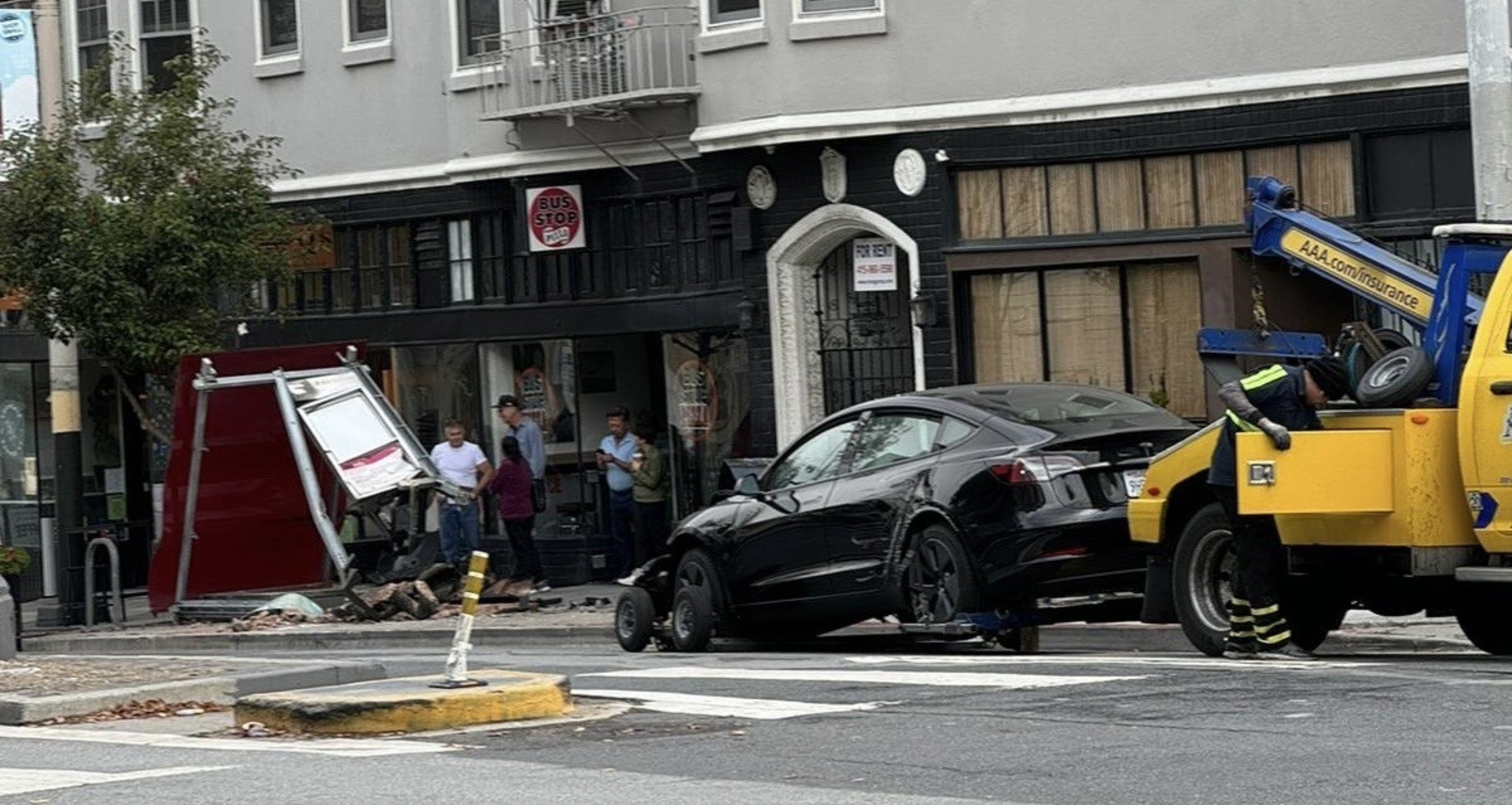A photo shared Tuesday with The Standard shows a tow truck preparing to remove a Tesla after a crash into a Divisadero Street Muni bus stop.