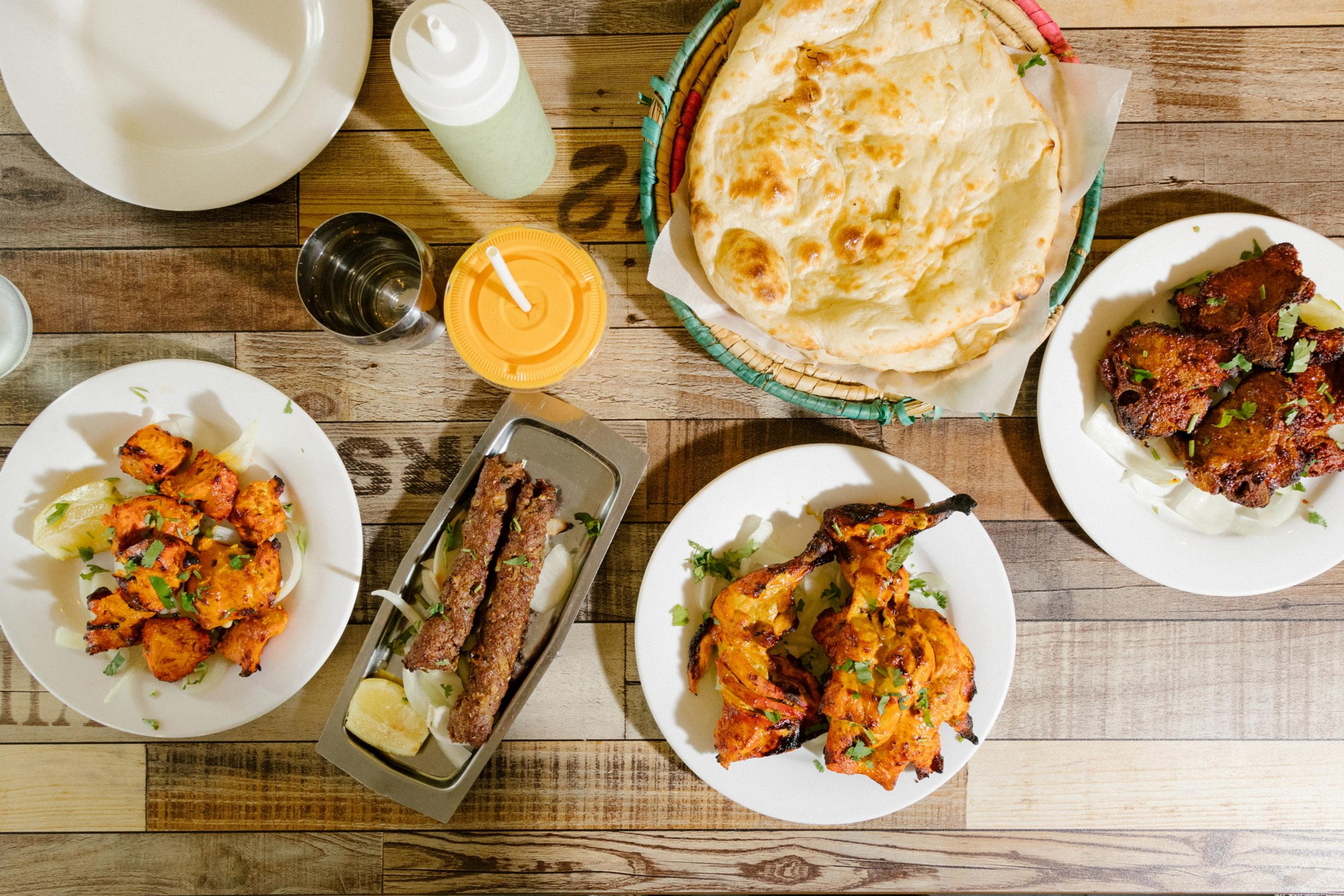 Chicken, seekh, chicken thigh, and lamb chop kabobs with naan and a mango lassi at Pakwan restaurant/