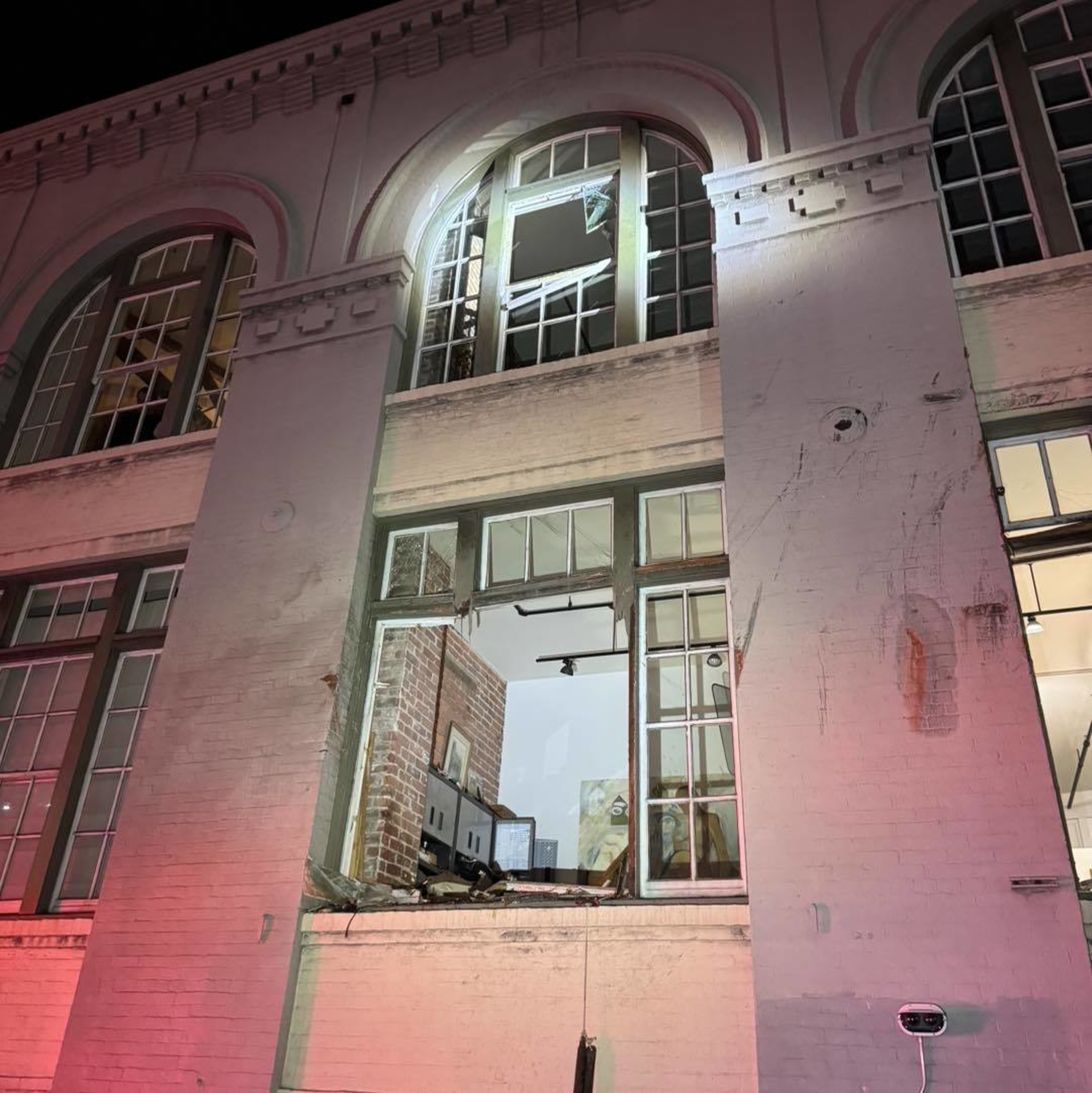 Several windows on a residential building are damaged. 