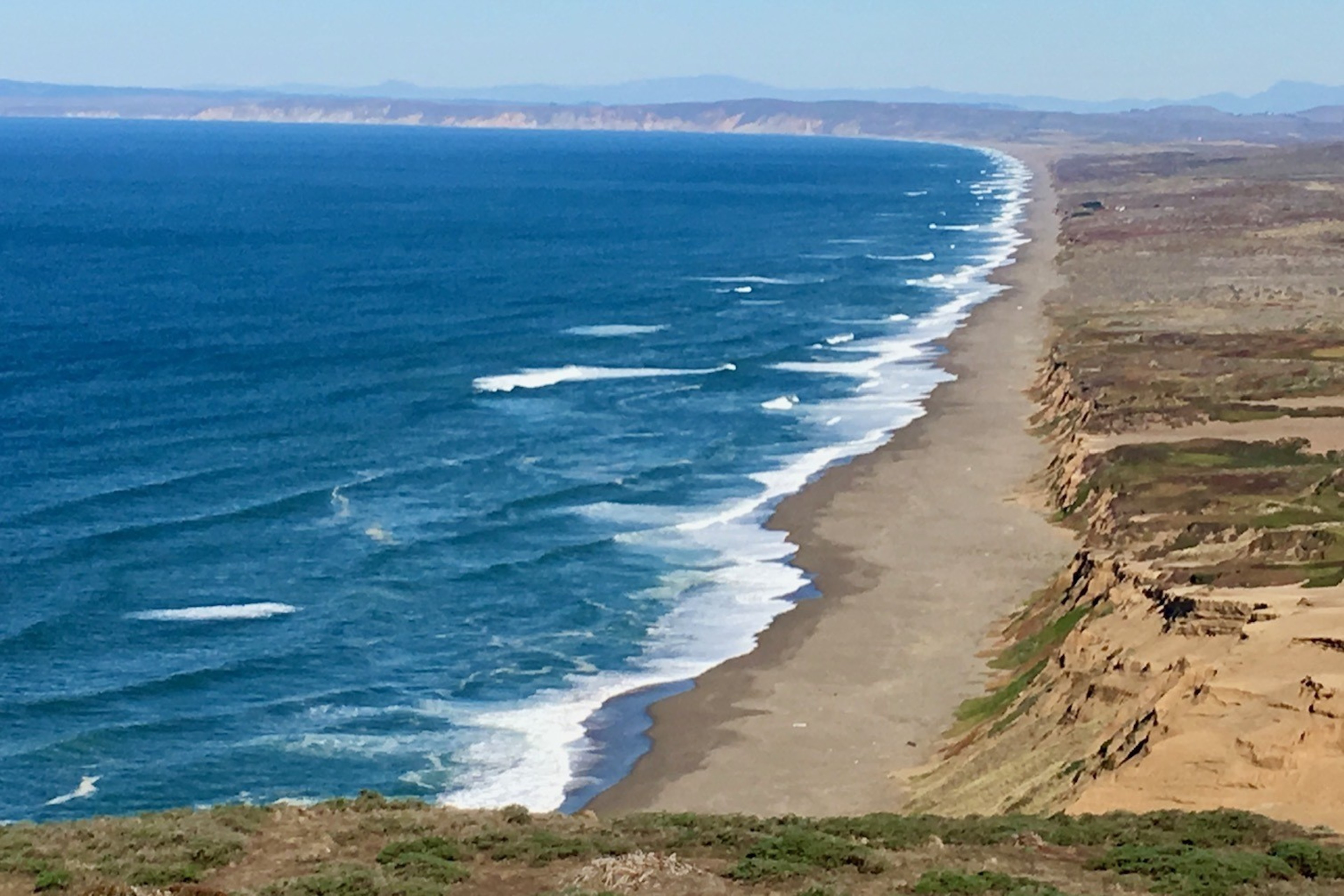 A beach and water are seen from a far.
