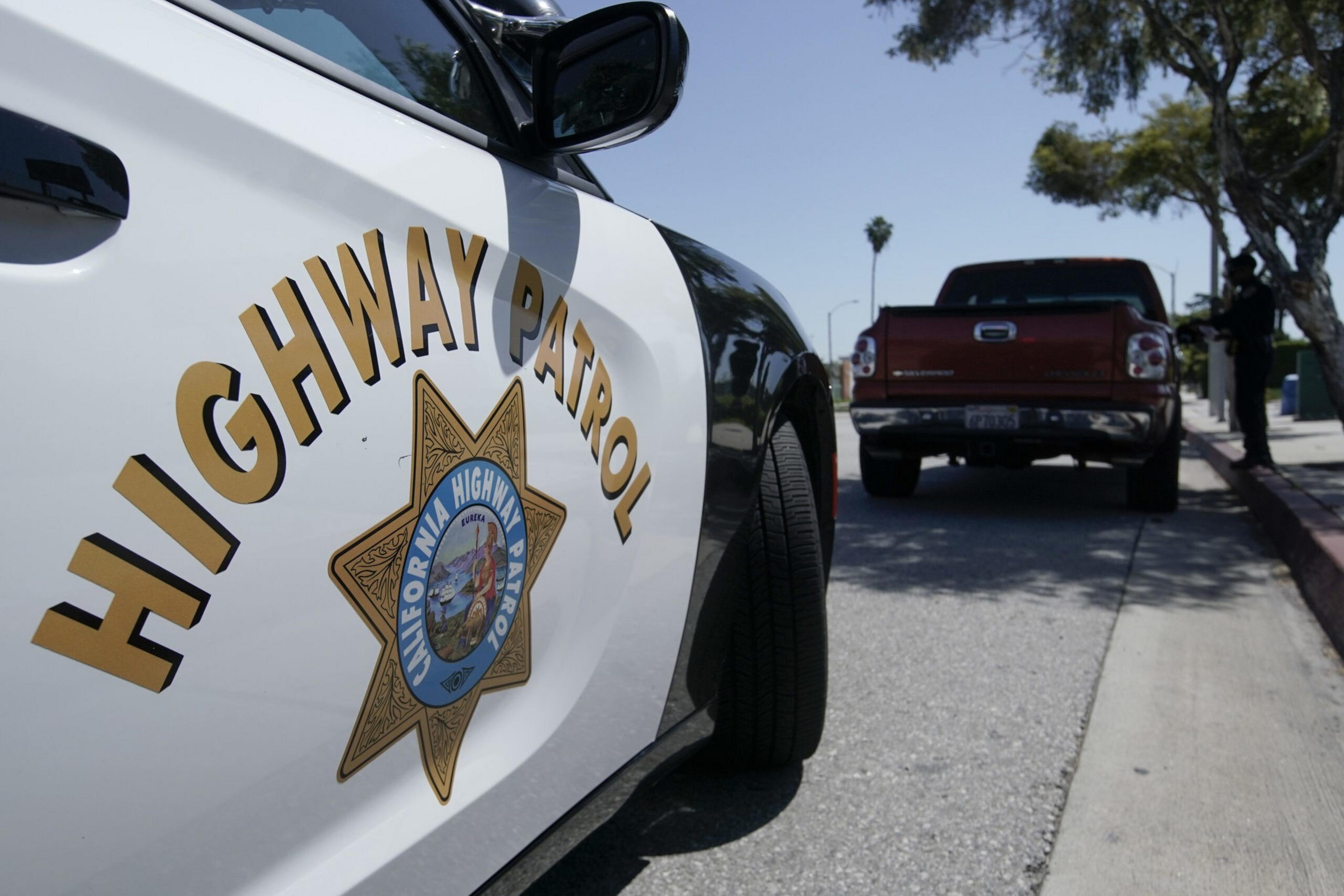 The door of a law enforcement patrol vehicle emblazoned with the California Highway Patrol logo.