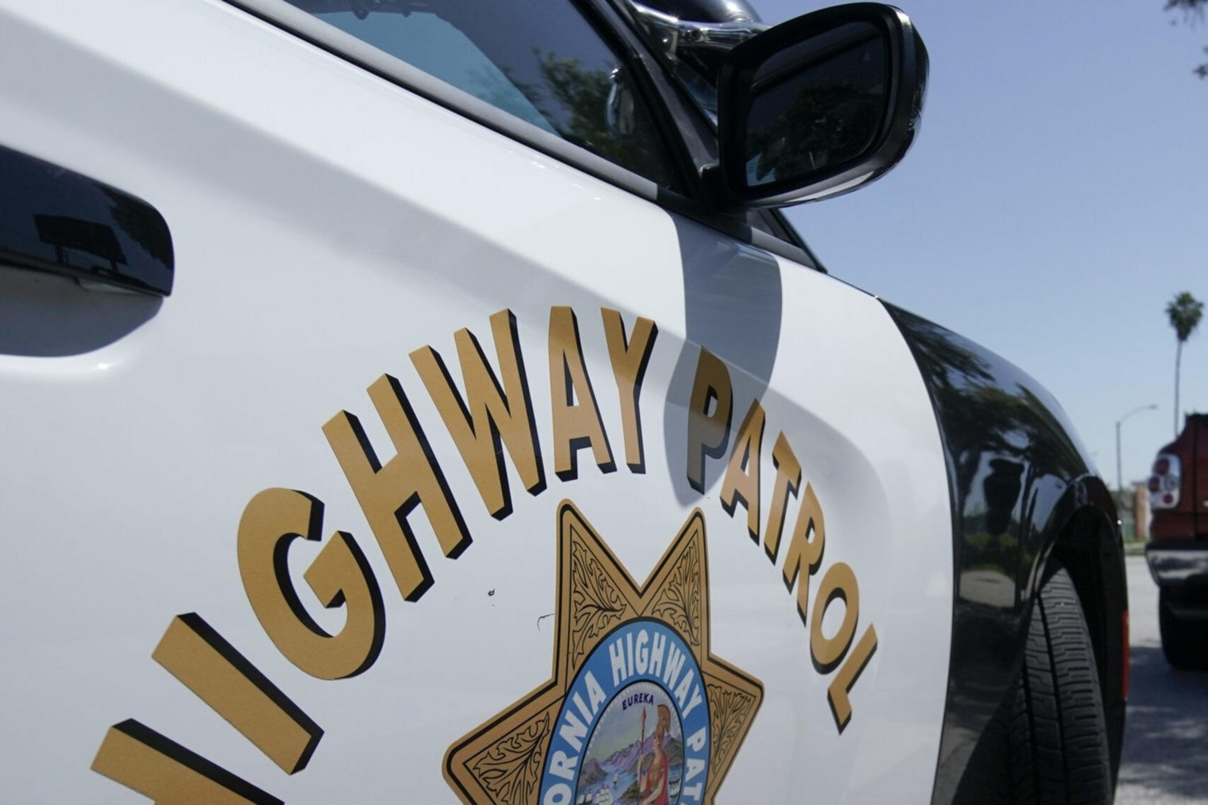 The door of a law enforcement patrol vehicle emblazoned with the California Highway Patrol logo.