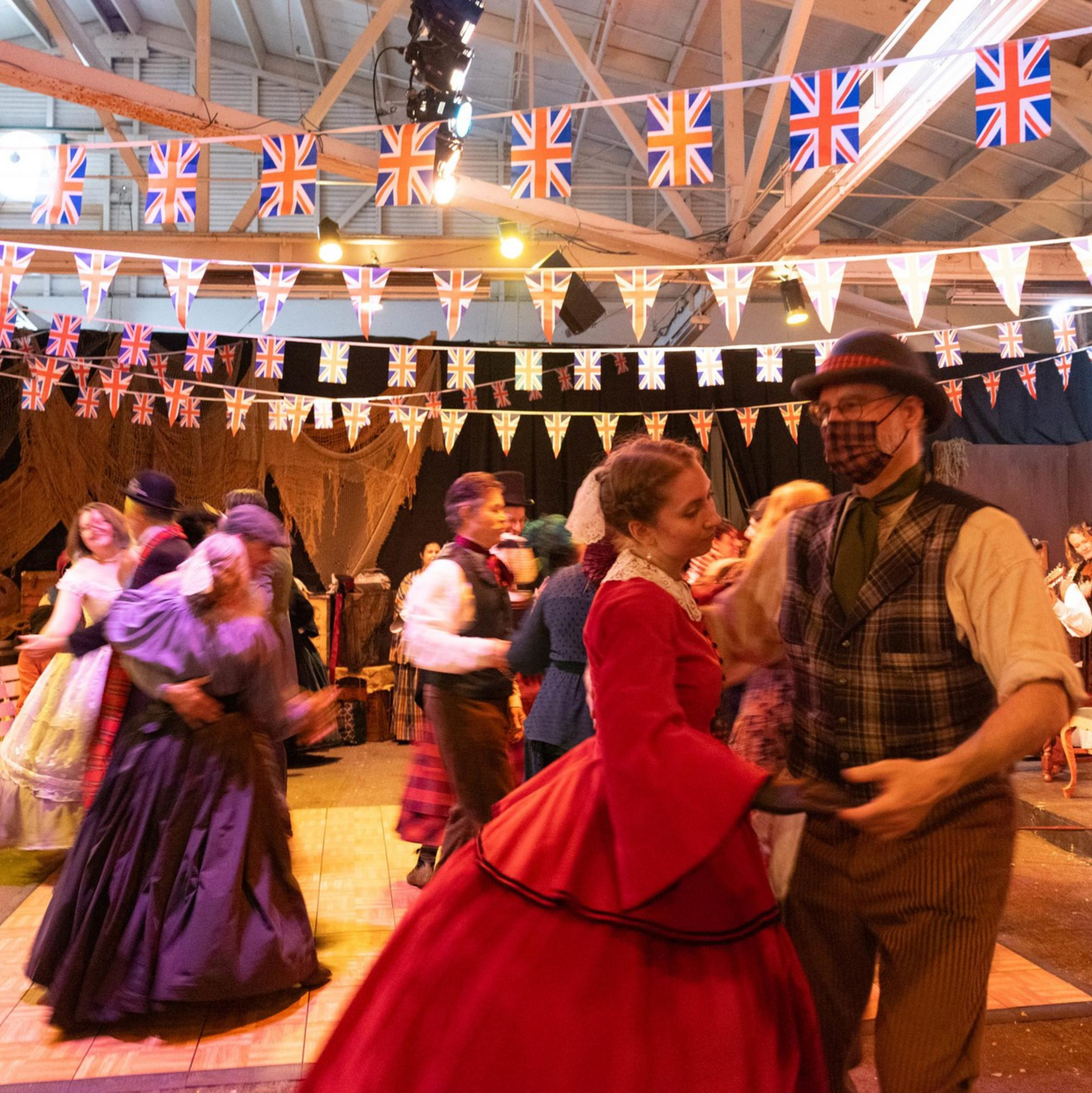 Couples dance while clad in Victorian era clothing at the Great Dickens Christmas Fair.
