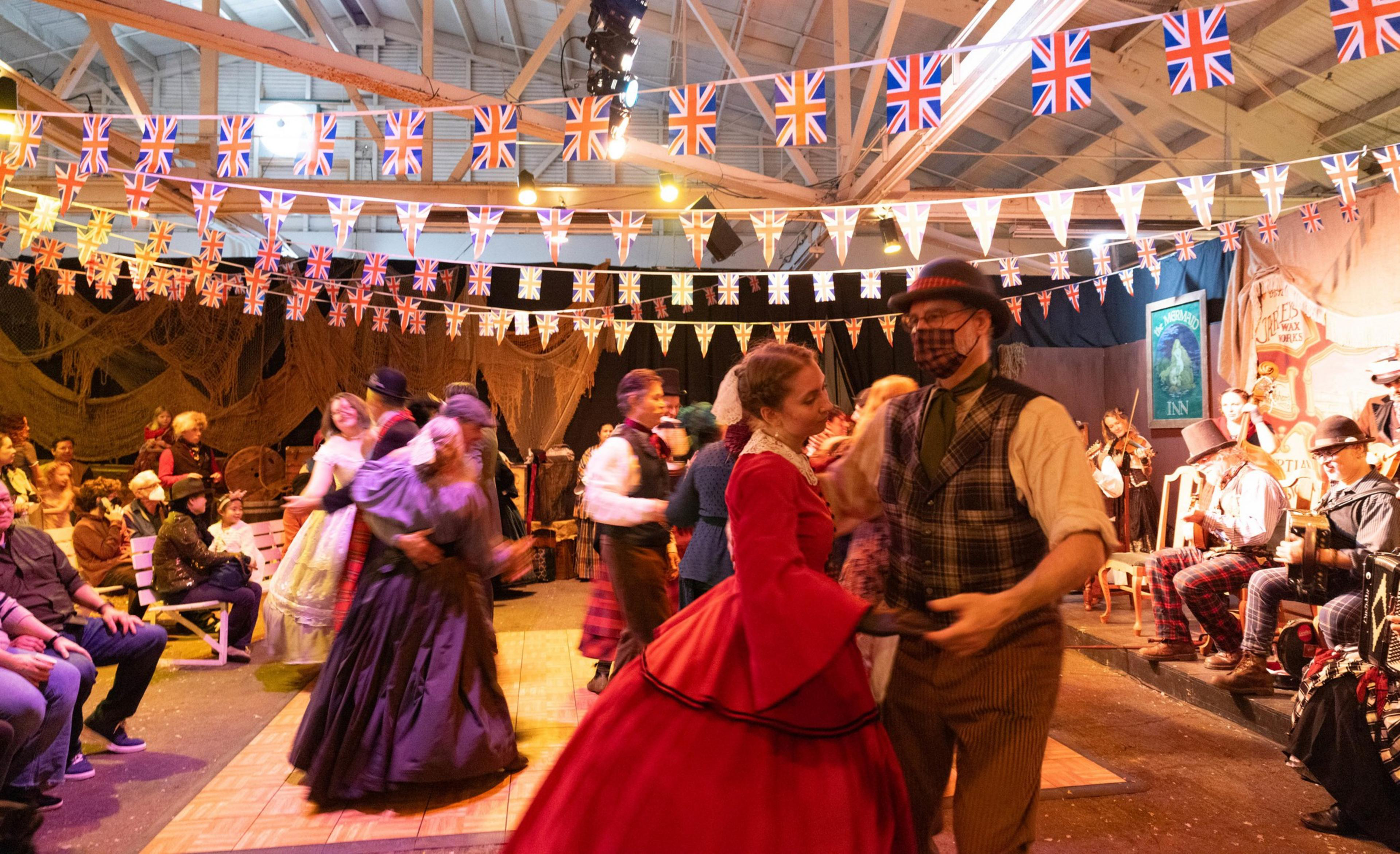 Couples dance while clad in Victorian era clothing at the Great Dickens Christmas Fair.