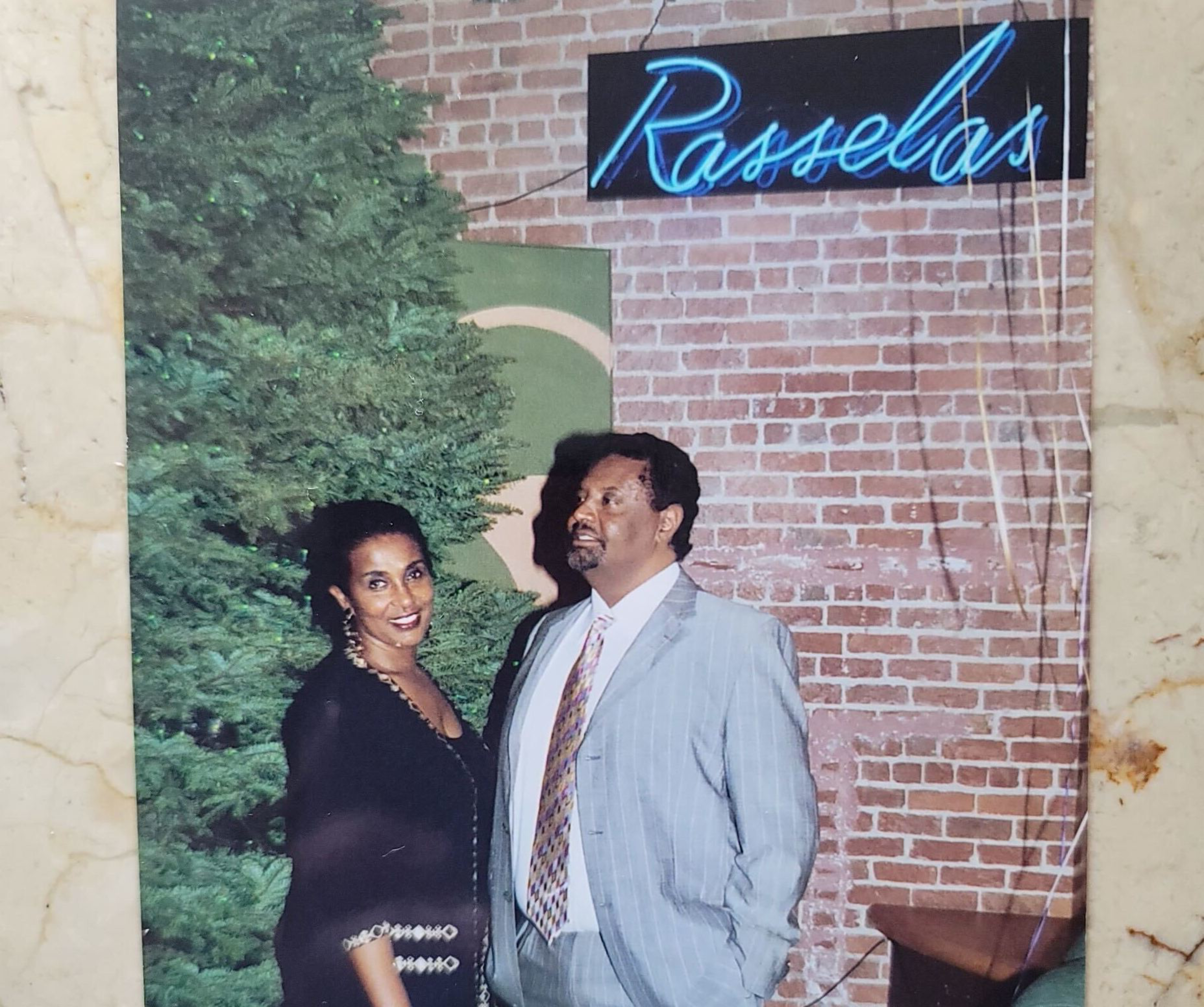 Agonafer Shiferaw and his wife, Net Alemayehu, pose for pictures near the Christmas tree at the Rasselas Jazz Club.