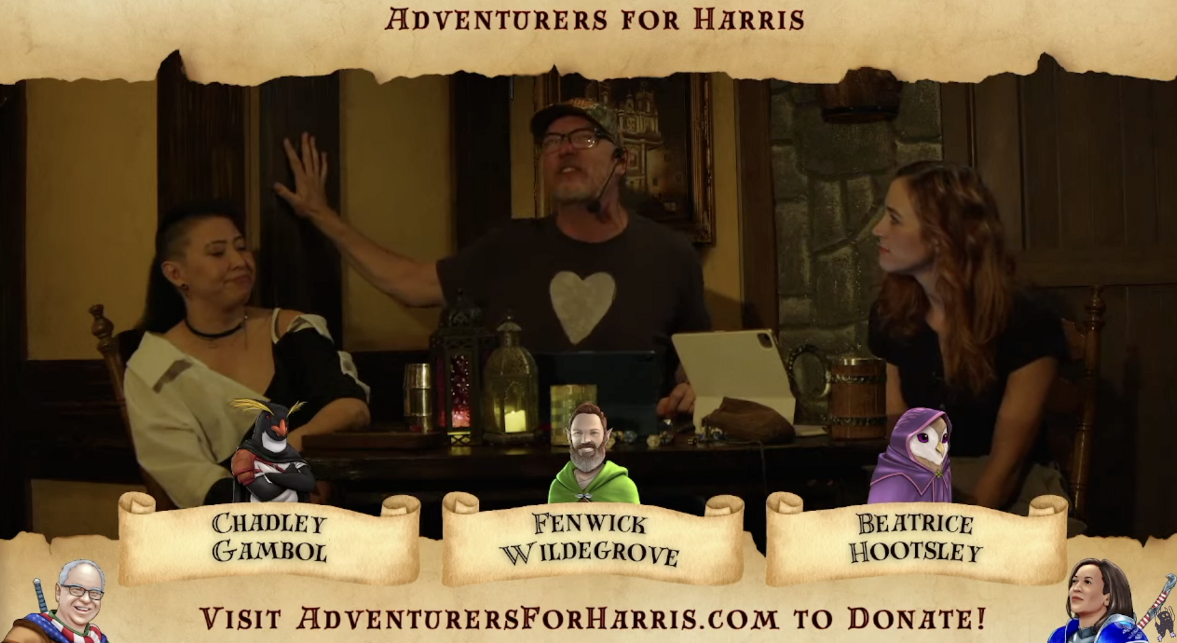 Three people sit at a table with microphones, candles, and various objects in a medieval-style room. The banner reads “Adventurers for Harris,&quot; with character names below.