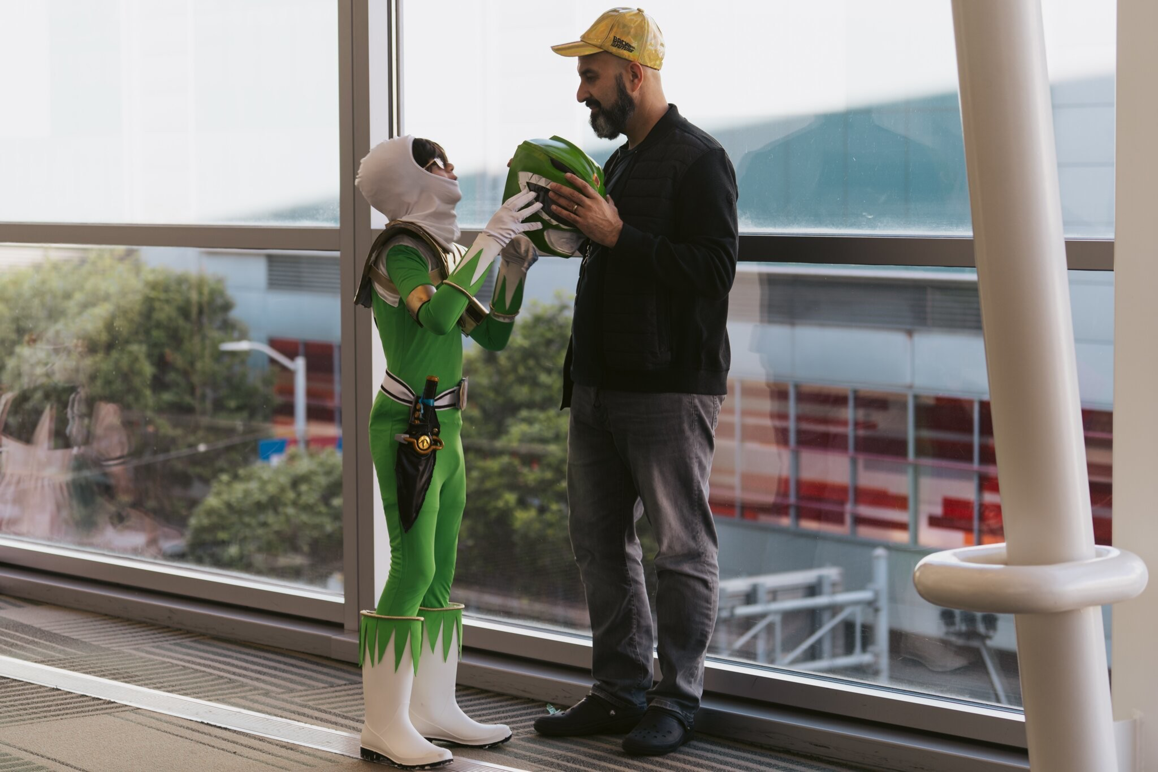 A woman in costume finishes preparing, with a man standing next to her.