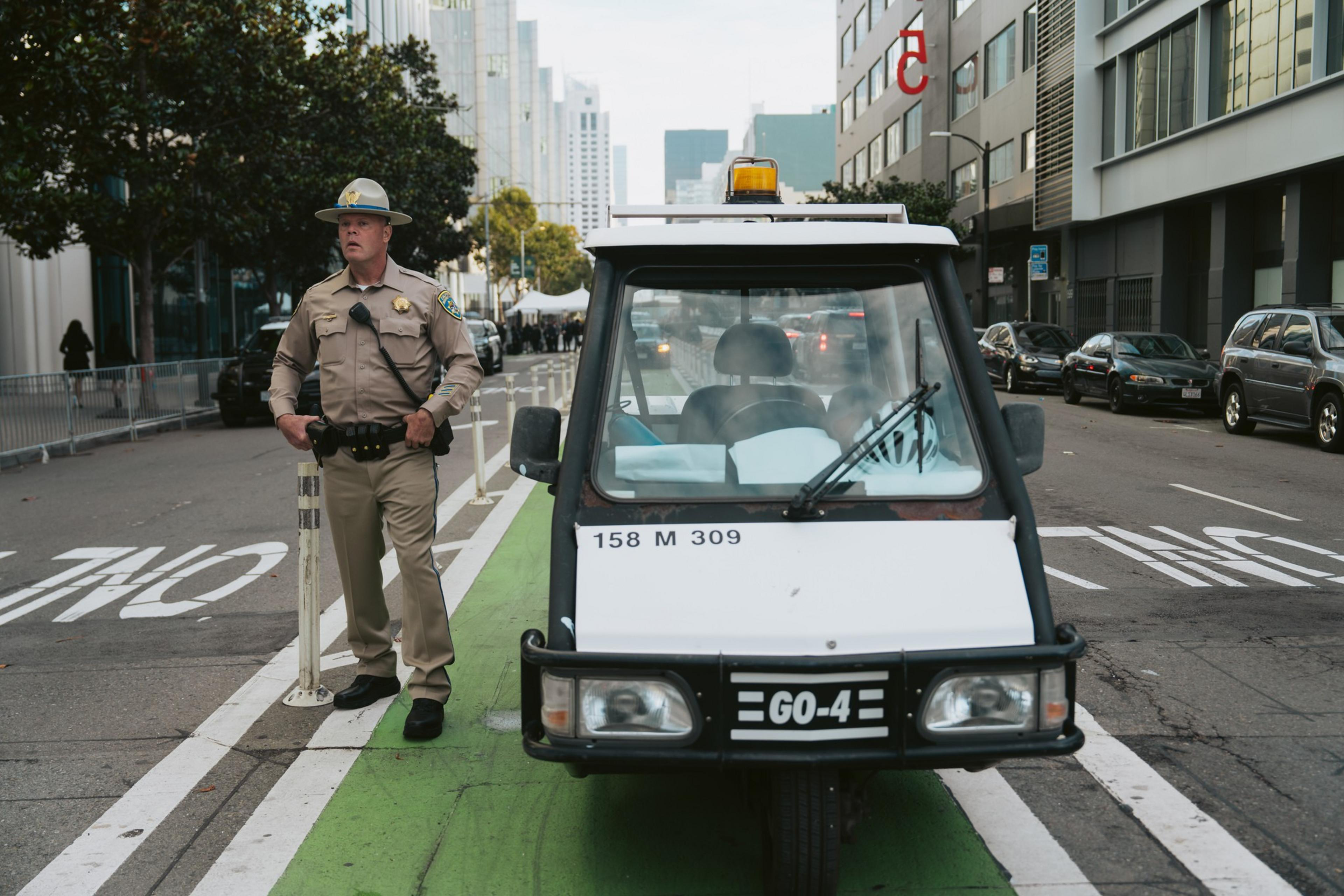 A California Highway Patrol officer stands on bicycle lane on a street closure.