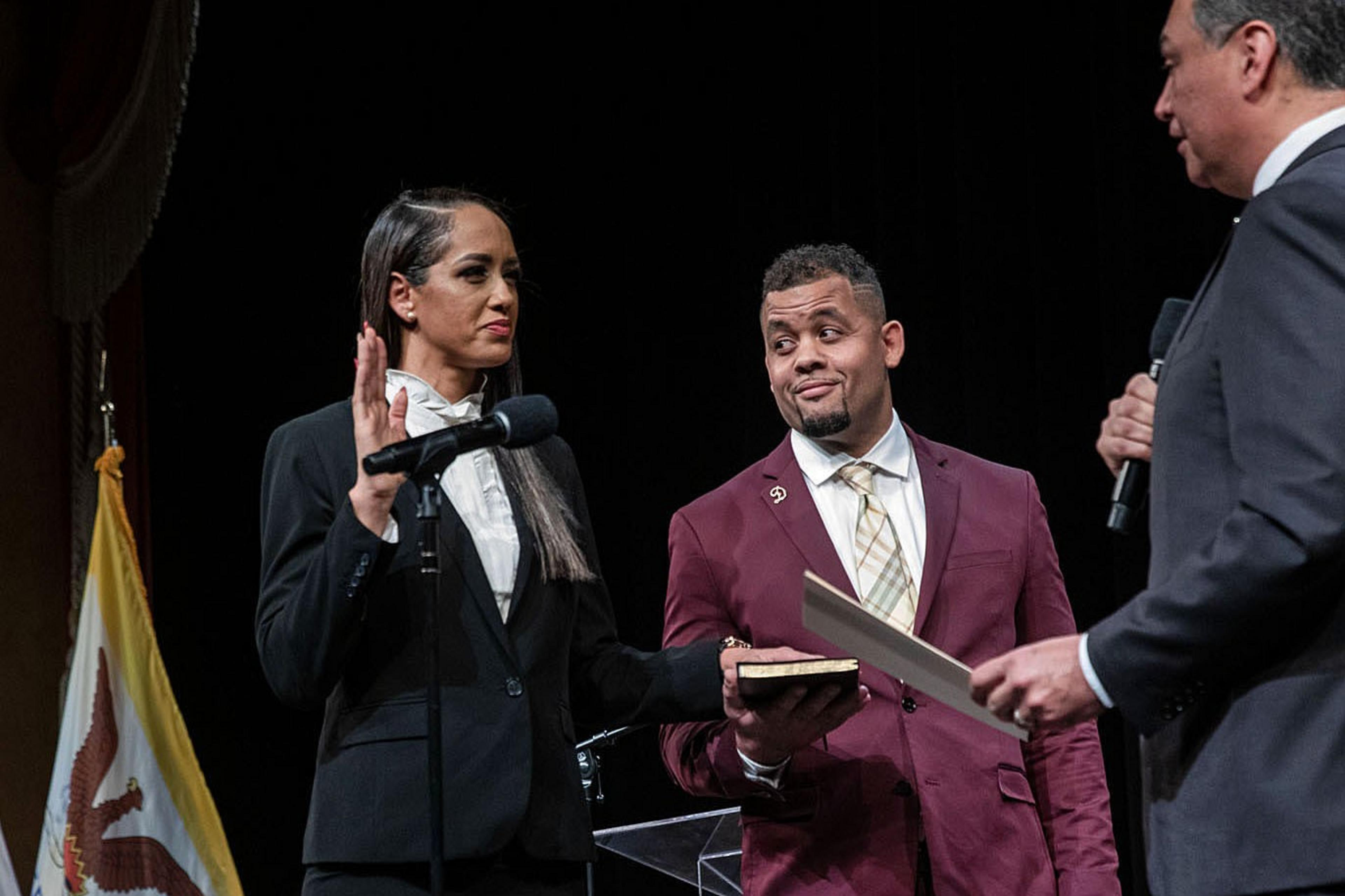 Three people stand on a stage.