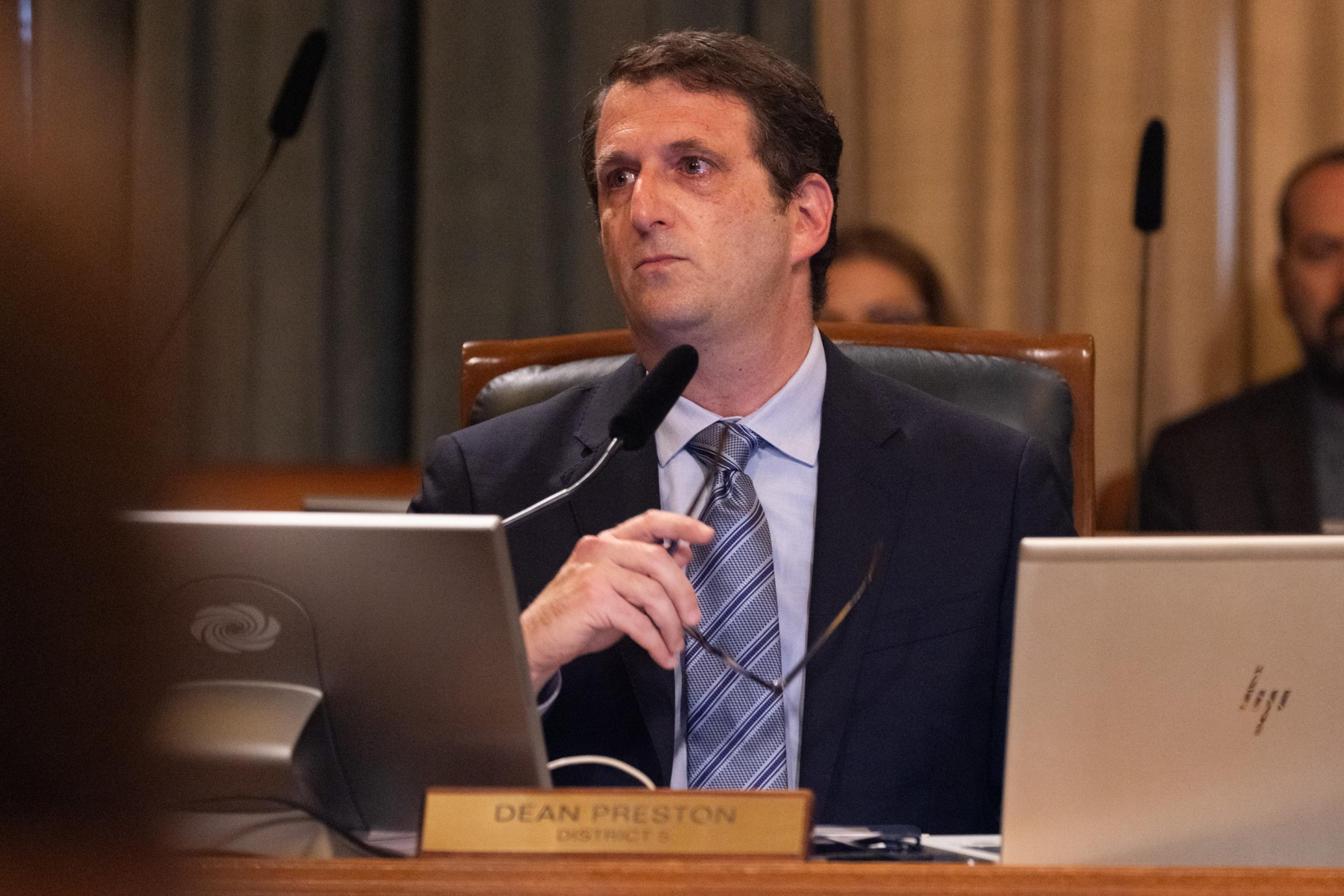 Supervisor Dean Preston looks to the side with his glasses in his hand.