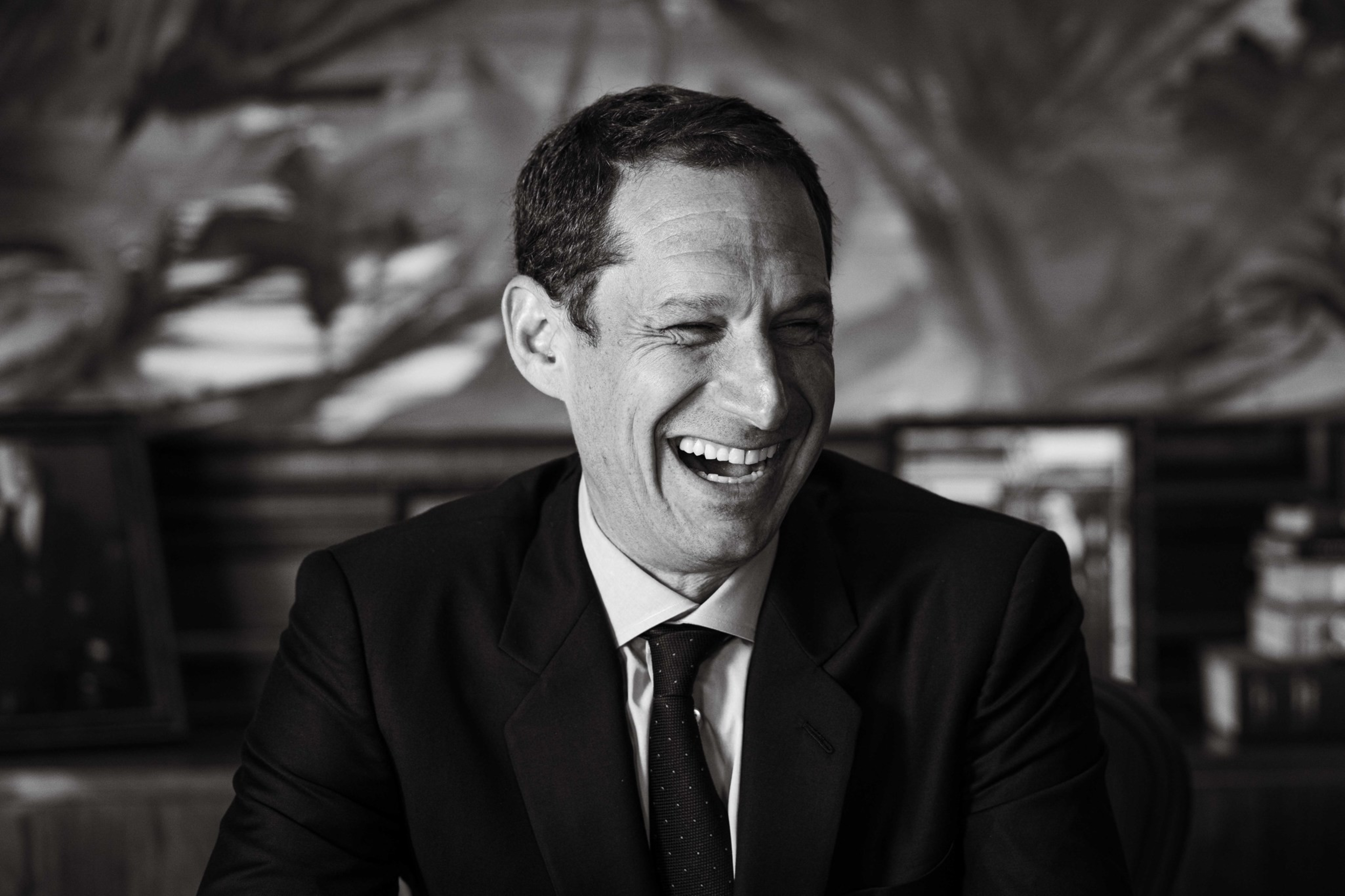 A black and white portrait of Daniel Lurie laughing.