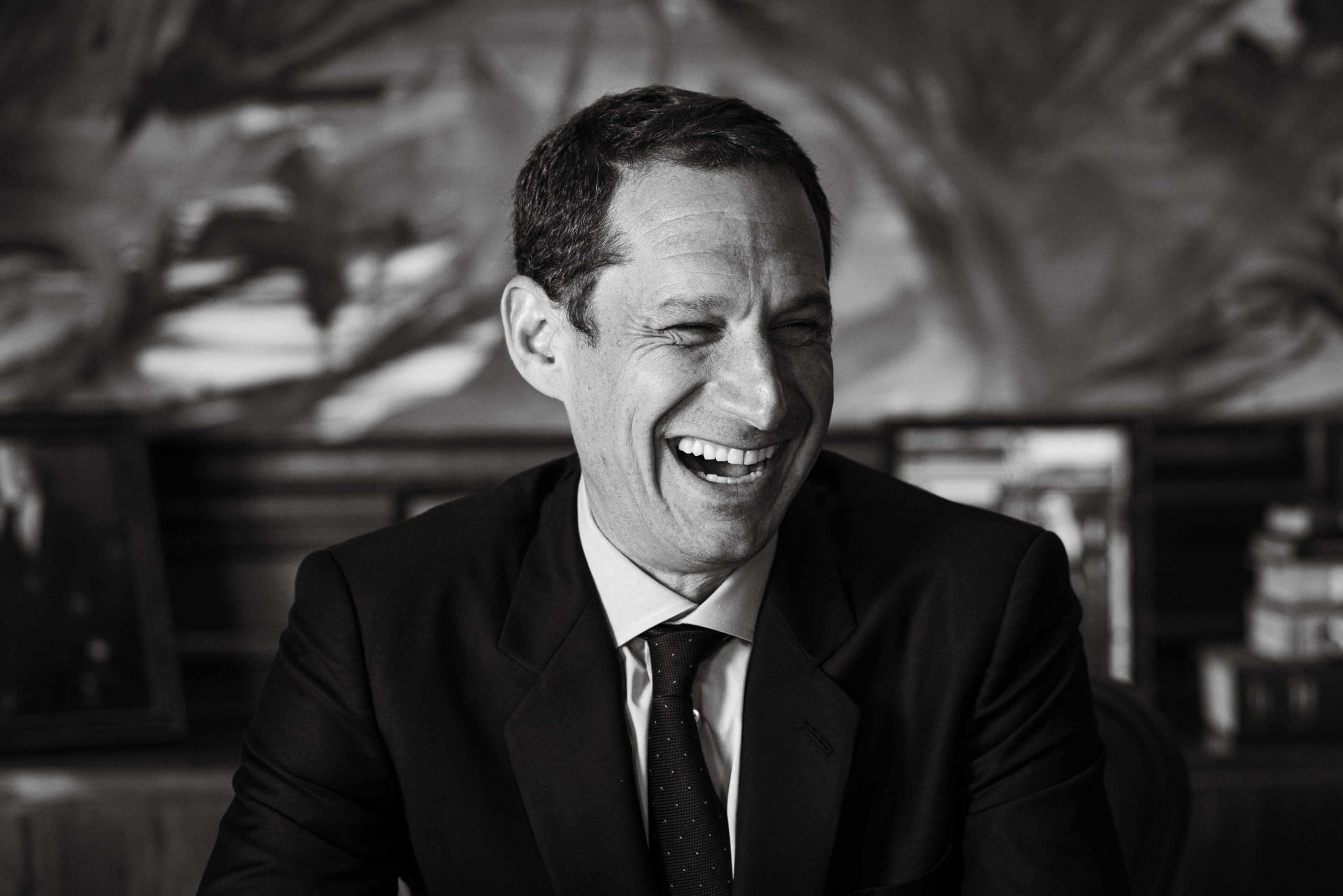 A black and white portrait of Daniel Lurie laughing.