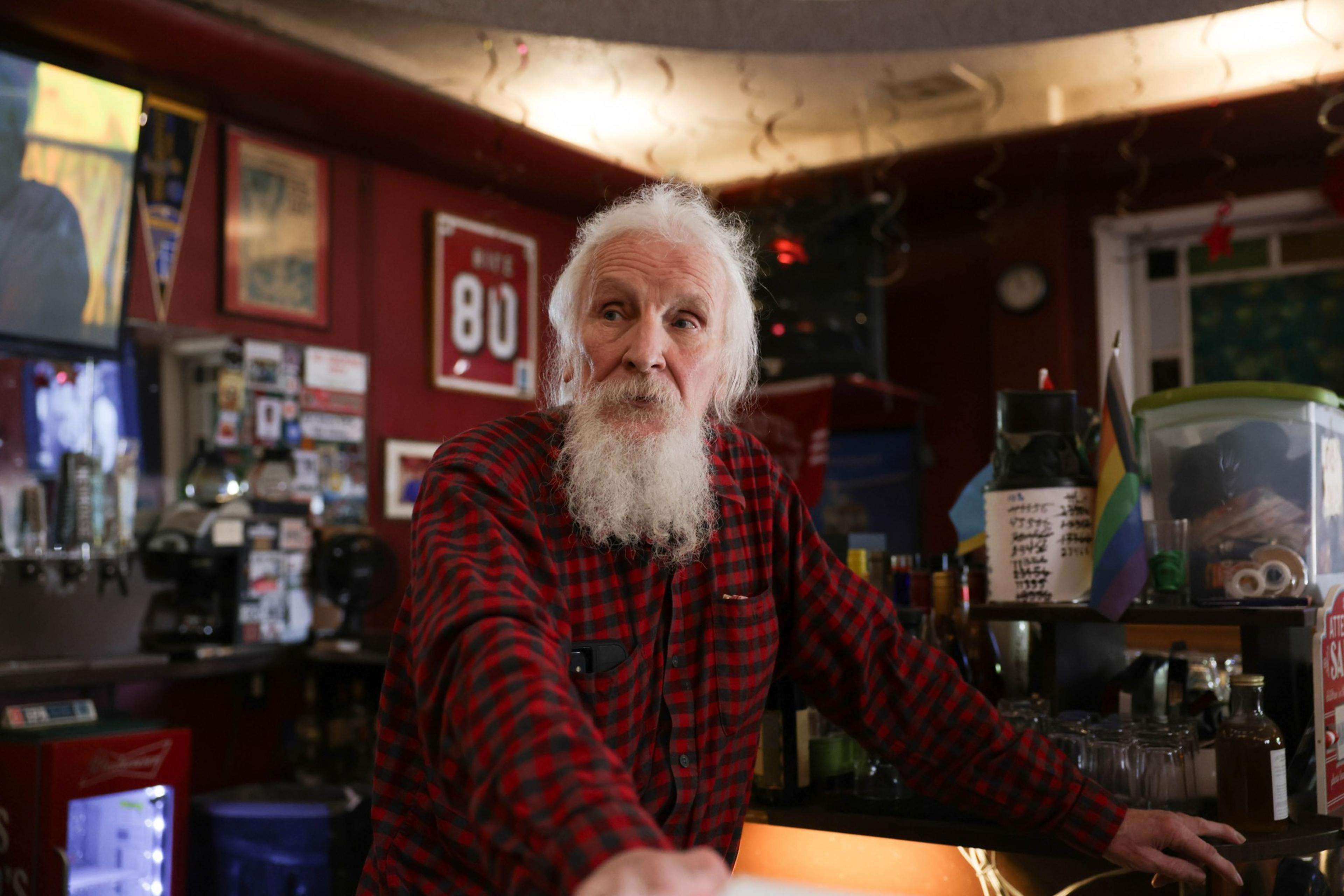 A man leans on a bar counter.
