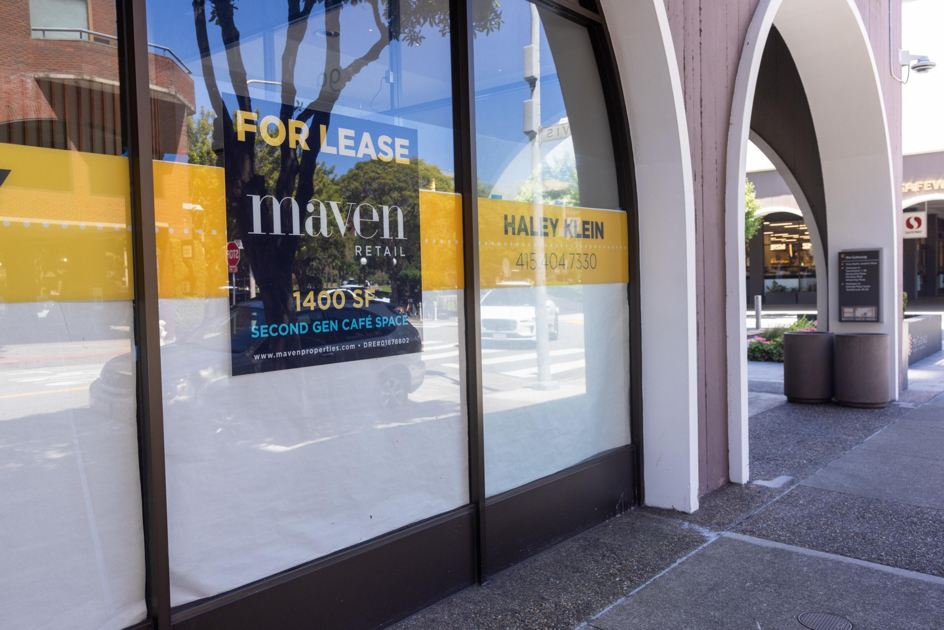 Empty retail space with glass windows displaying "For Lease" signs, advertising 1400 square feet of second generation café space.