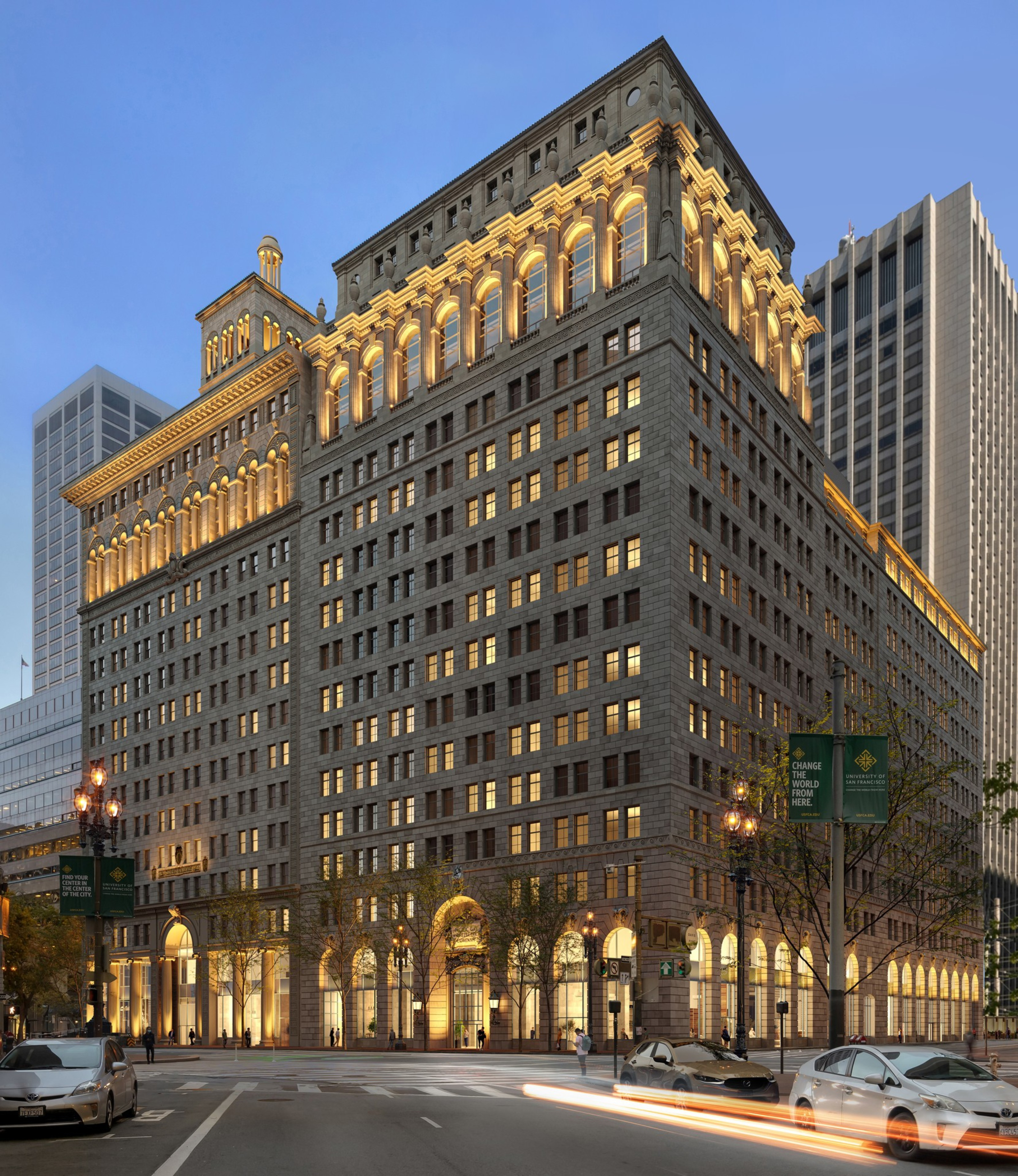 A historic multi-story building brightly lit at dusk, with illuminated arches and architectural details. Cars are visible on the surrounding streets.