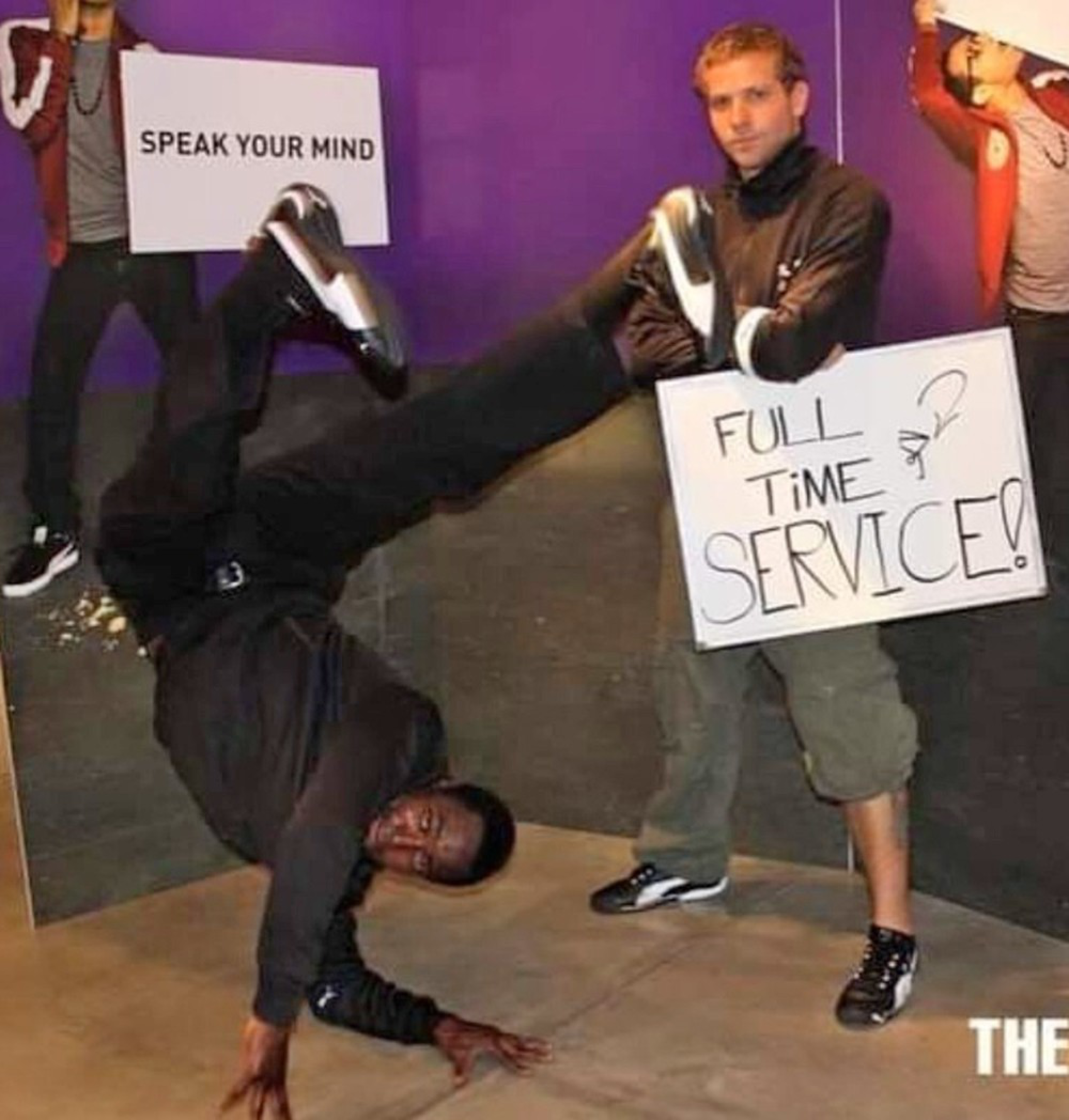 A man breakdancing on one hand wears black while another man holds a sign reading "FULL TIME SERVICE!" against a purple background.