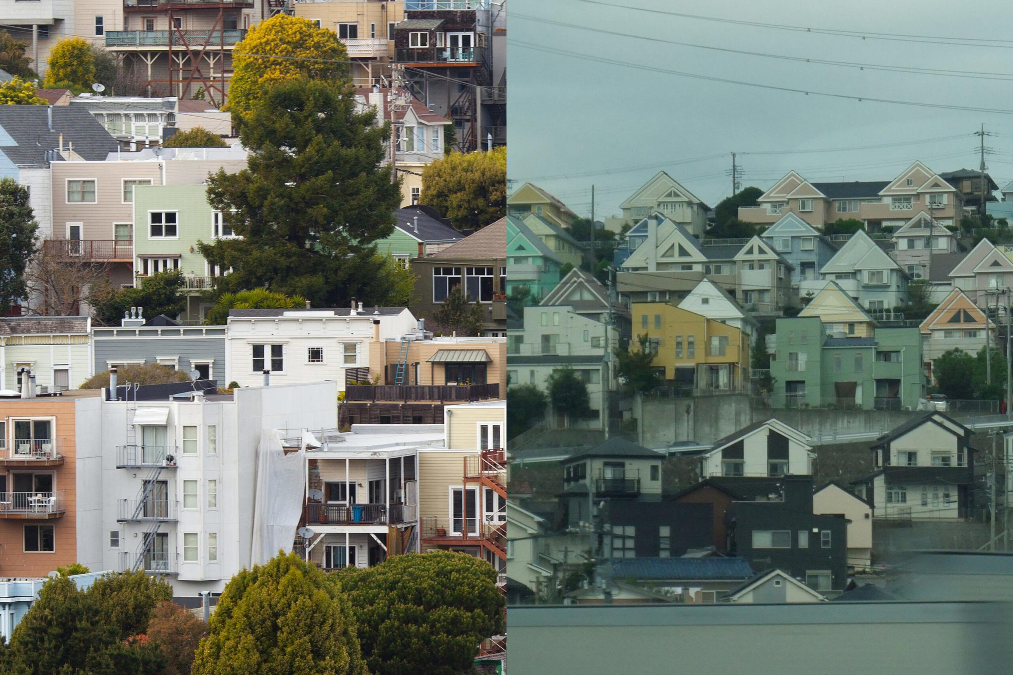 A cluster of multi-story houses with varied pastel colors and balconies sits among trees on the left, while densely packed homes with triangular roofs appear on hilly terrain on the right.