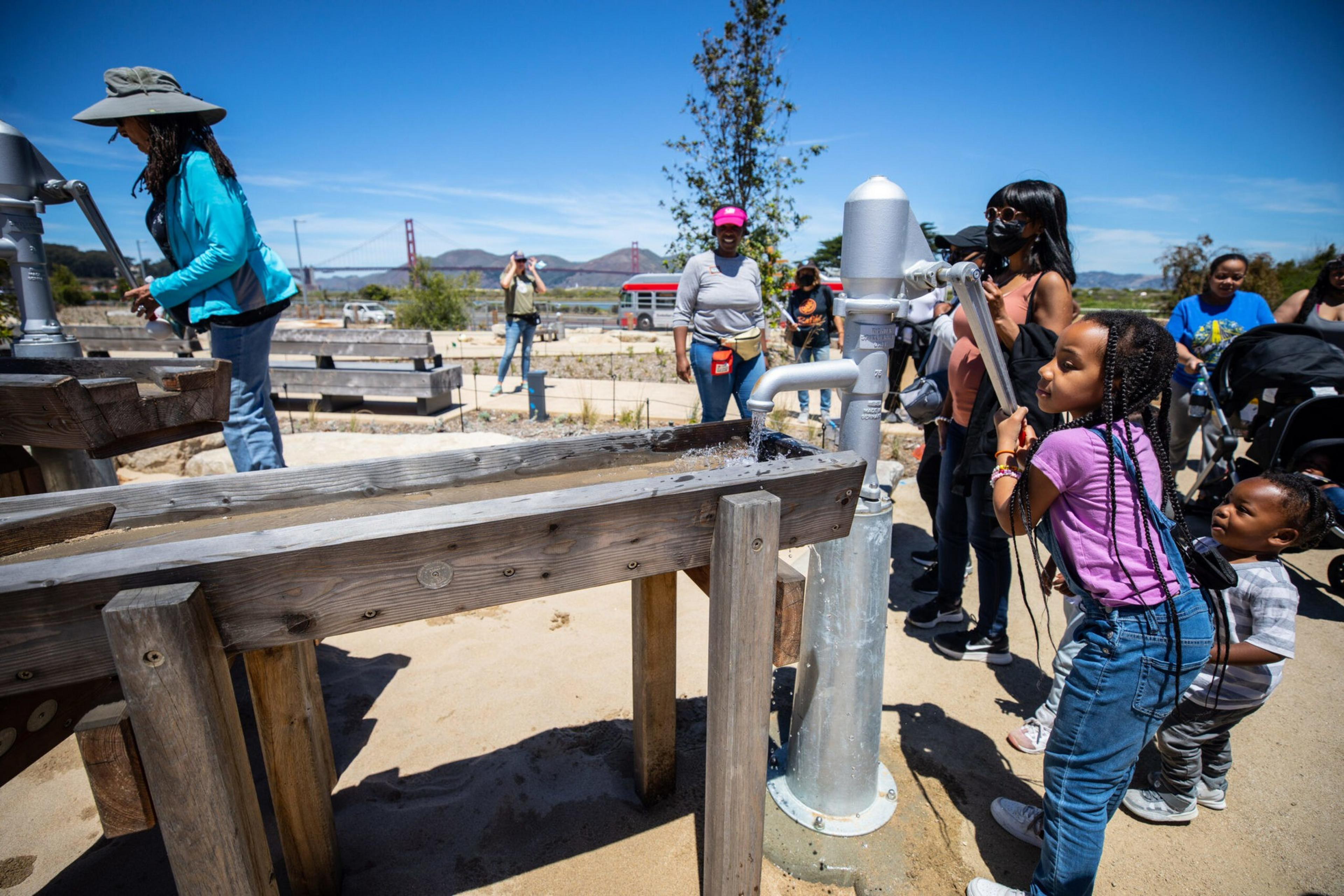 Some kids play with a water flume at a playground.