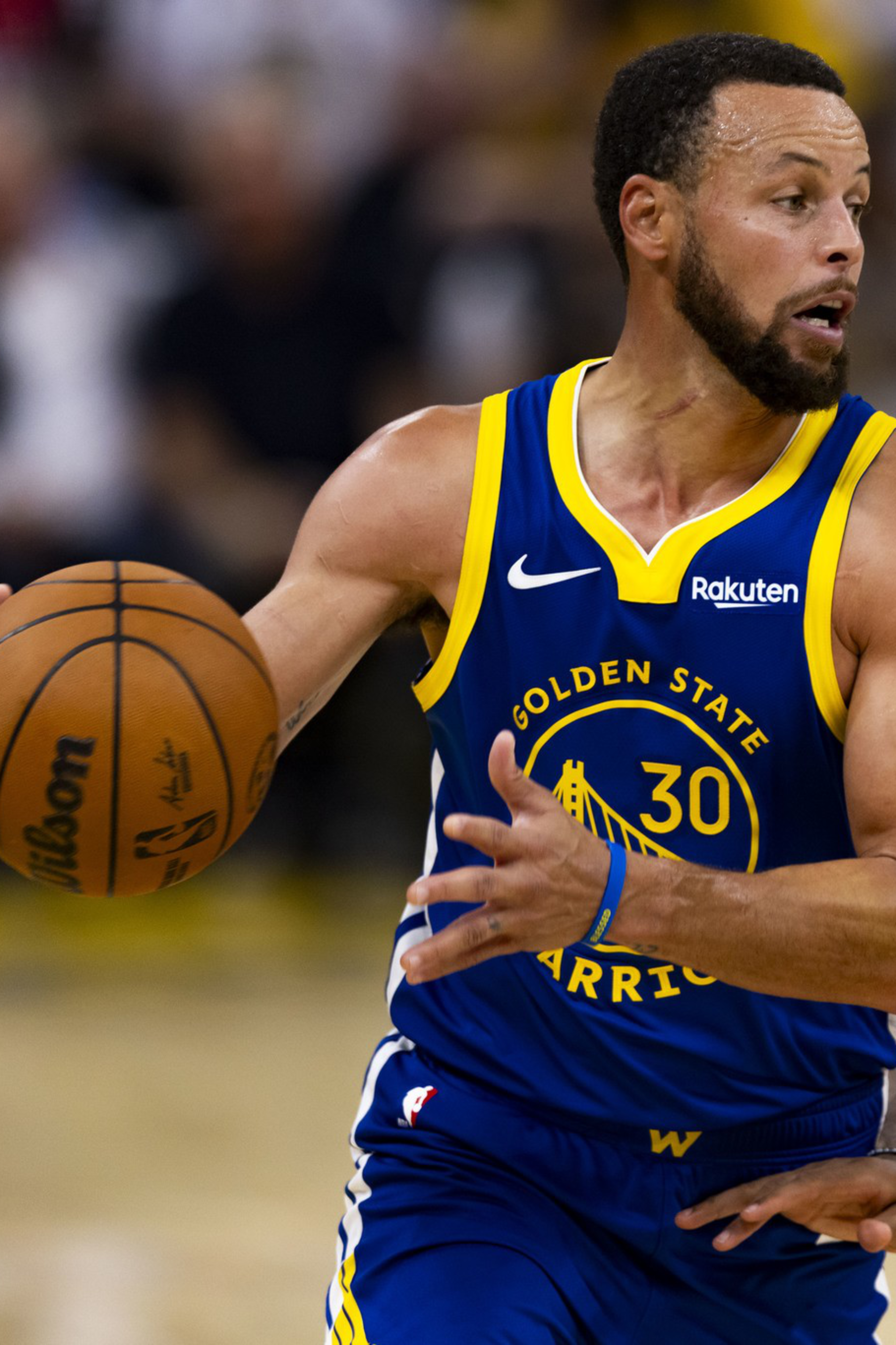A Golden State Warriors player wearing number 30 is dribbling a basketball while closely guarded by a Phoenix Suns player wearing number 0.