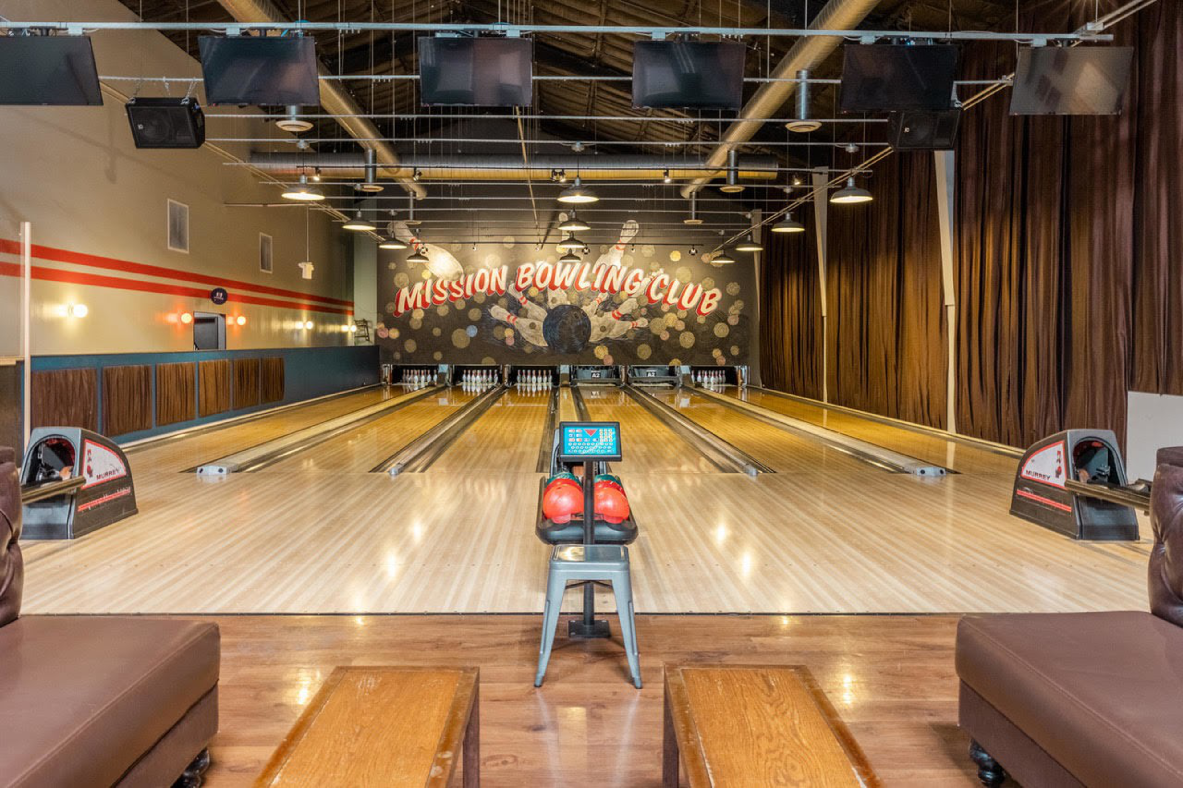 A stool sits in the middle of a bowling alley.