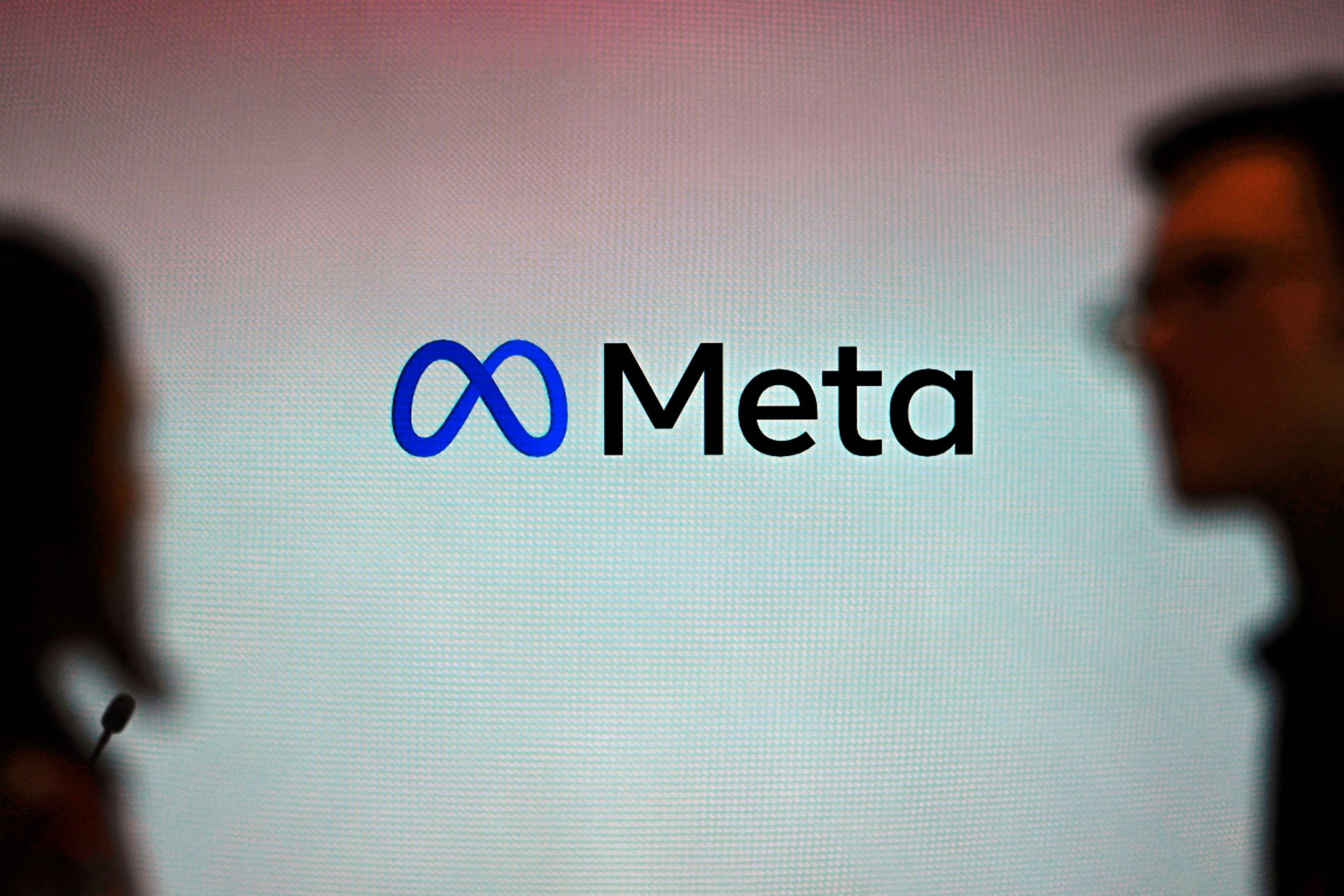 The image features the Meta logo, a stylized infinity symbol, with the word "Meta" beside it. Silhouettes of two people face each other in the foreground.