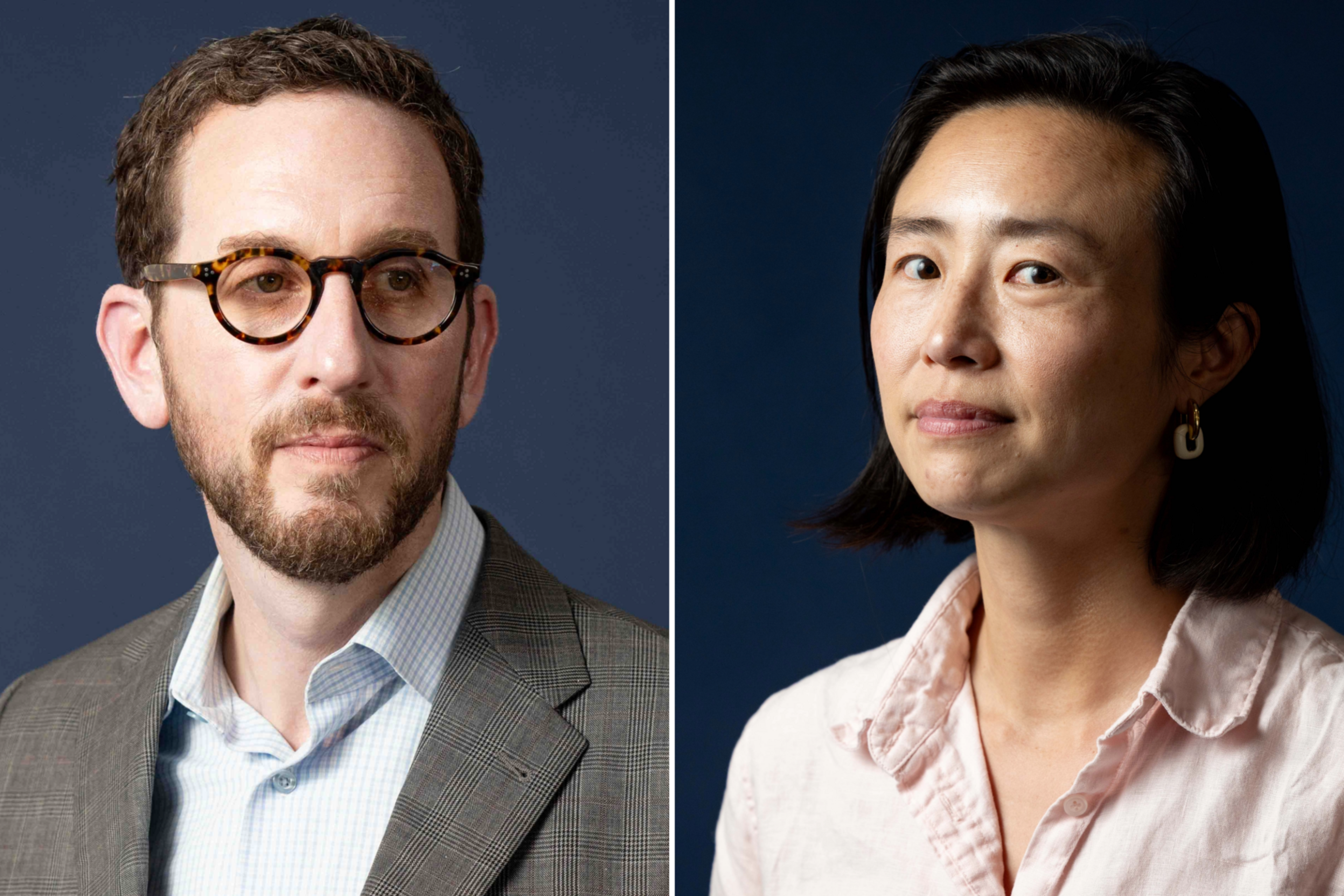 A man with short curly hair, beard, and tortoiseshell glasses wears a checkered blazer and light blue shirt, a woman with short black hair wears a pale pink shirt.