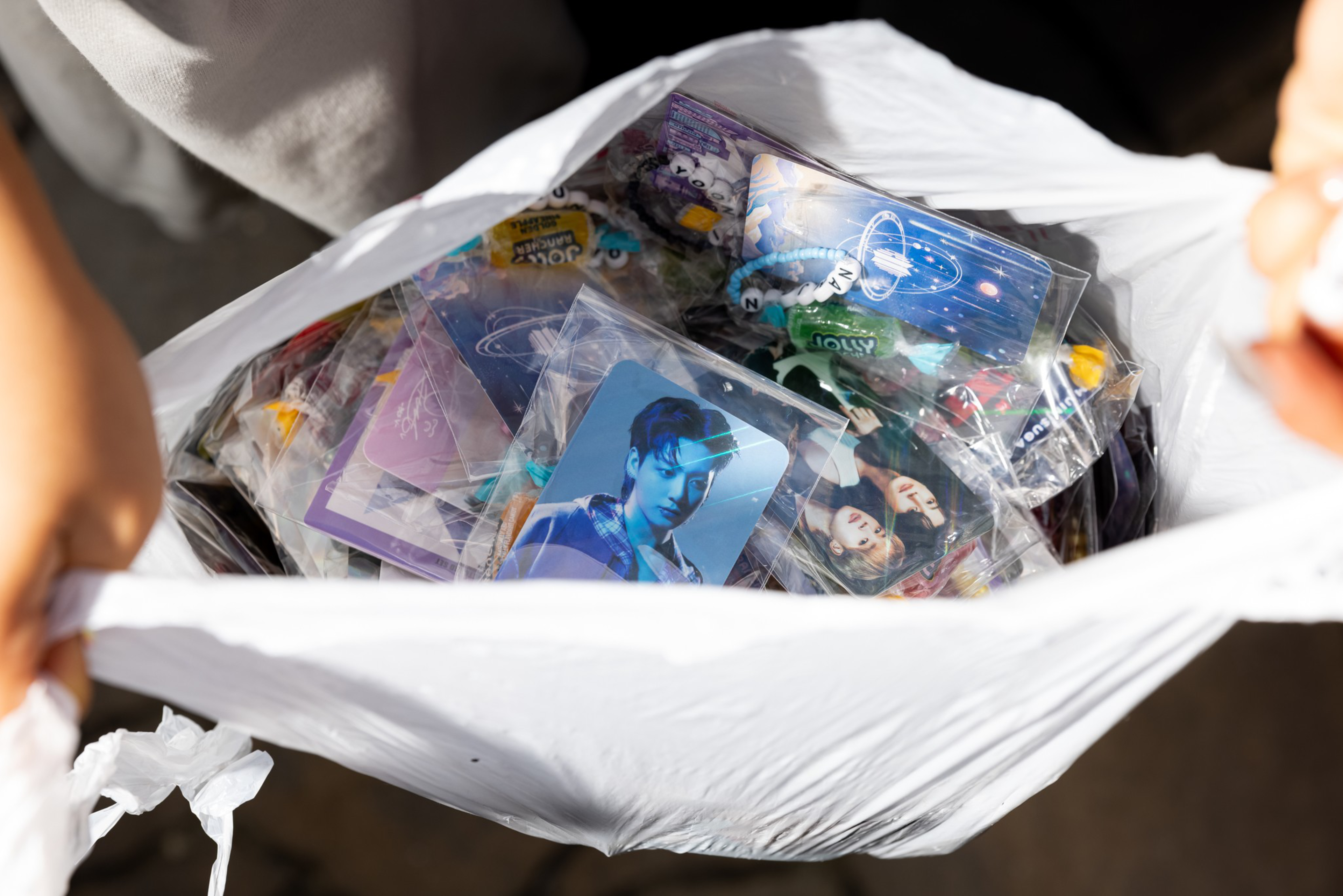 A plastic bag filled with various collectible cards featuring portraits, designs, and themes related to pop culture or music idols.