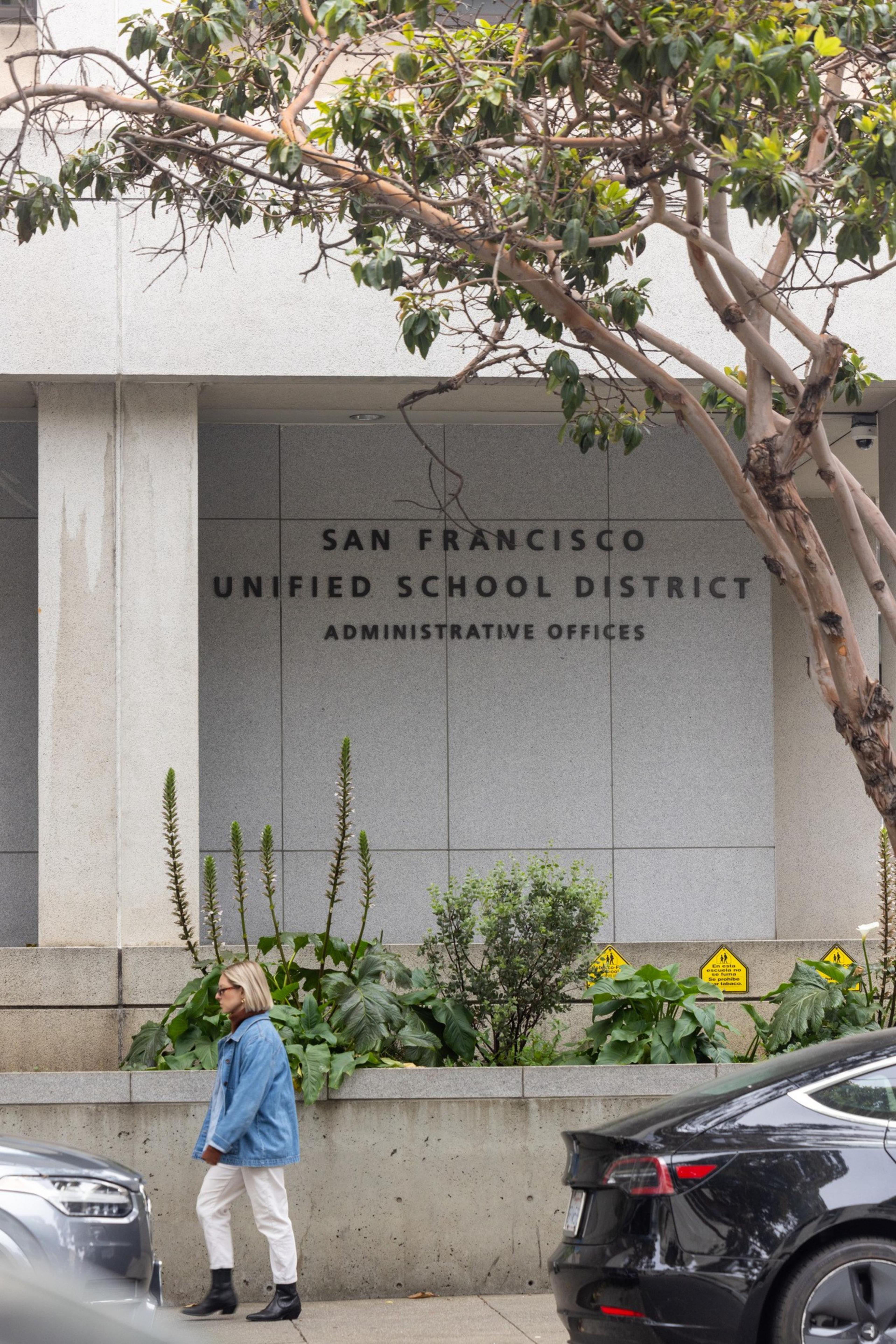 A woman walks in front of the SFUSD administrative offices.