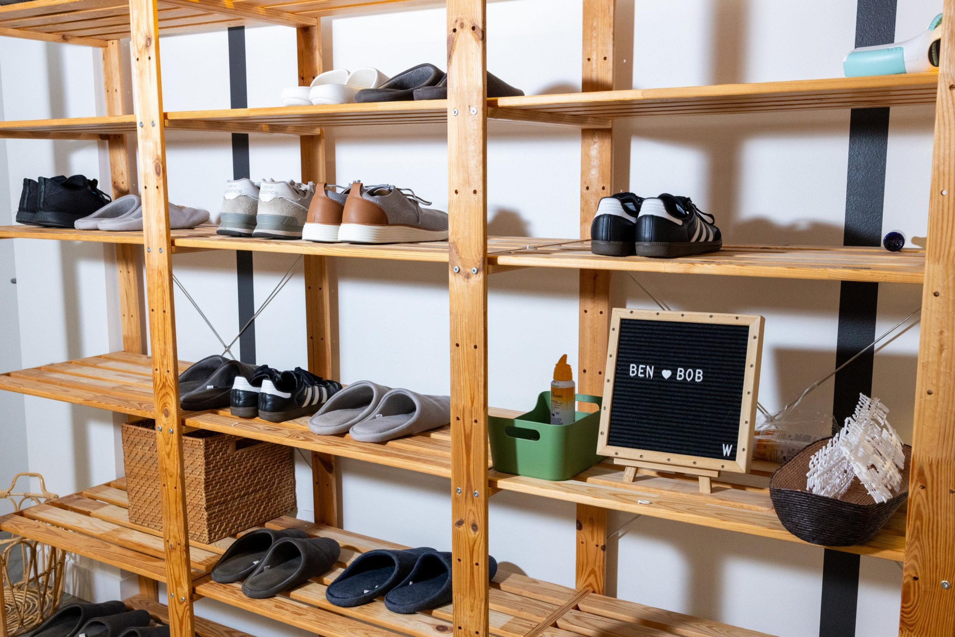 Wooden shelves hold various pairs of shoes, a small basket, a green container with a bottle, and a black letter board reading "BEN ♥ BOB".