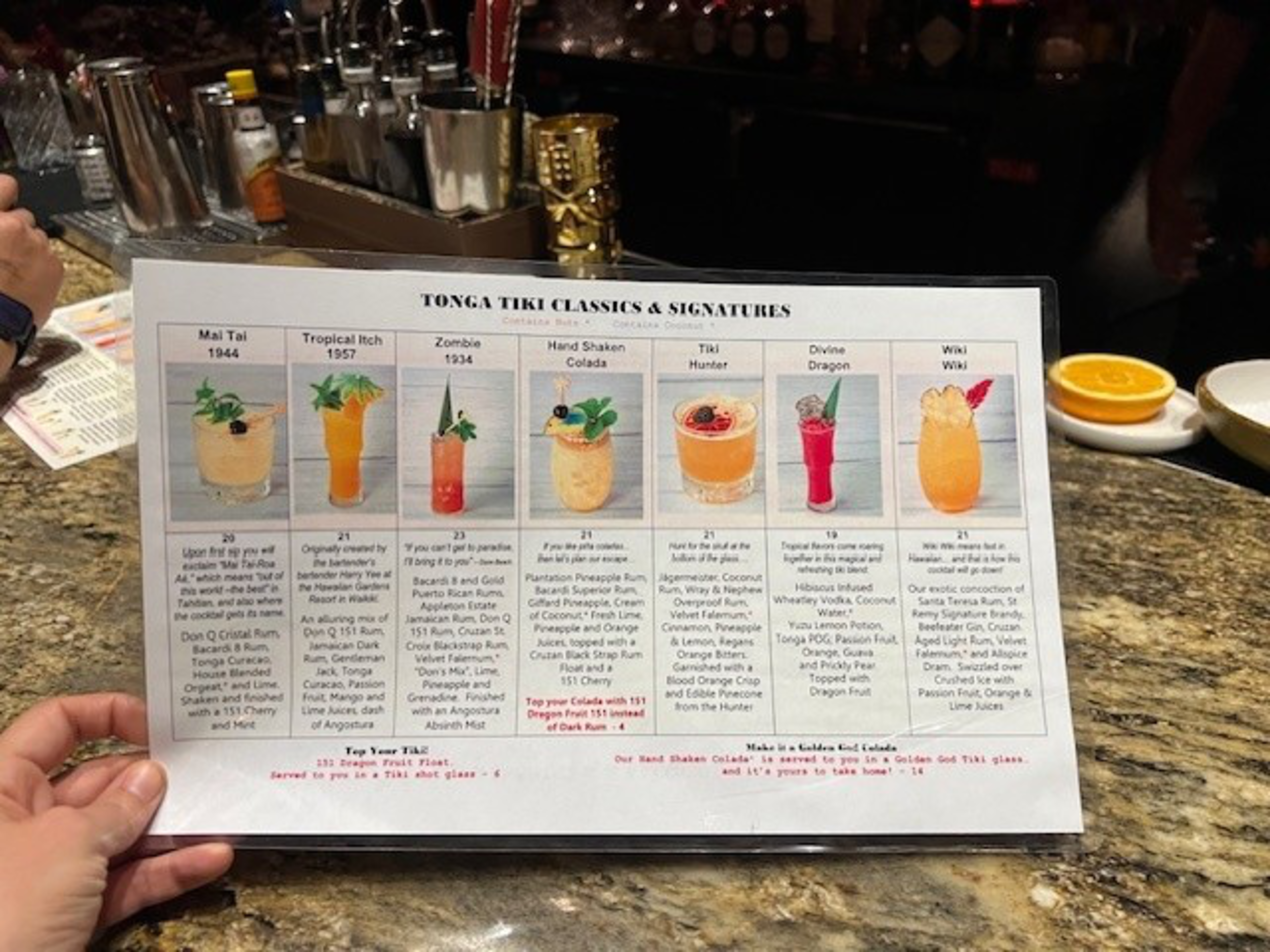 A menu shows seven different tiki cocktails.