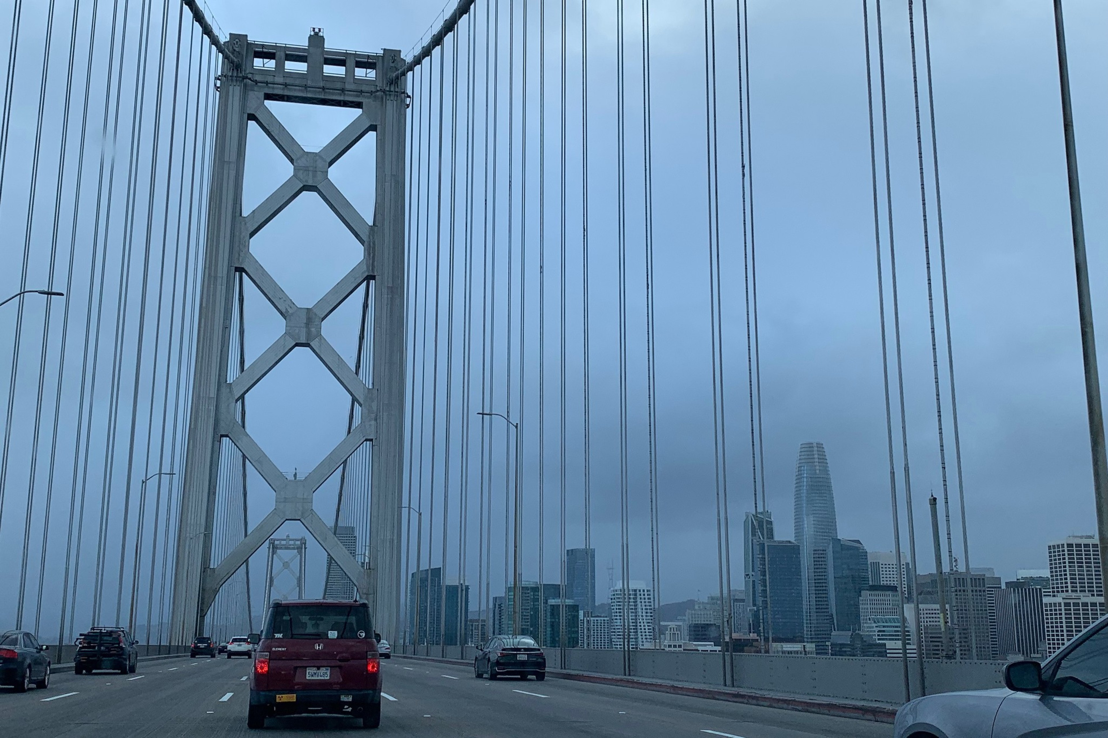 A view of cloudy skies and a city skyline from an elevated bridge