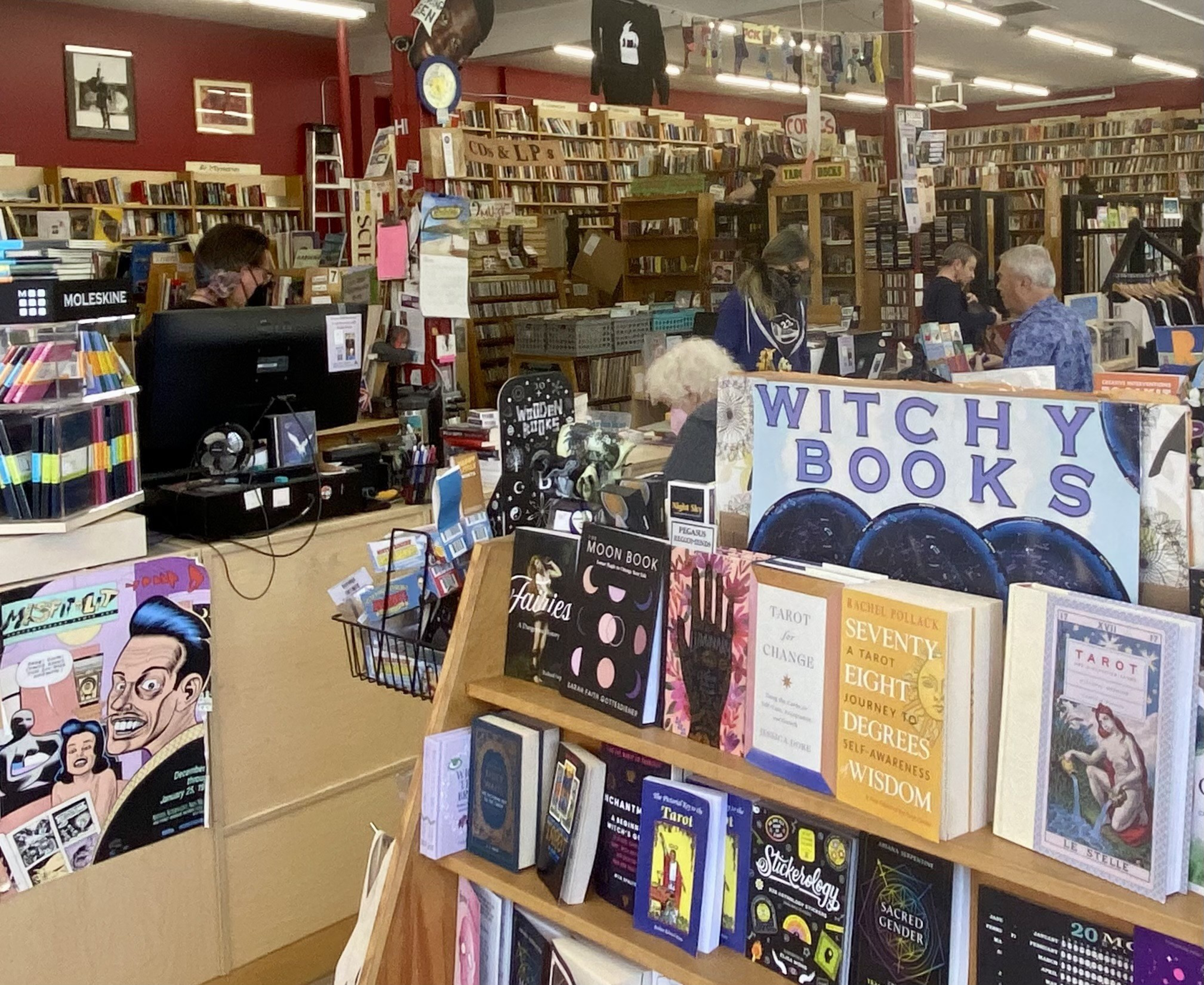 A shelf filled with books with a store in the background.