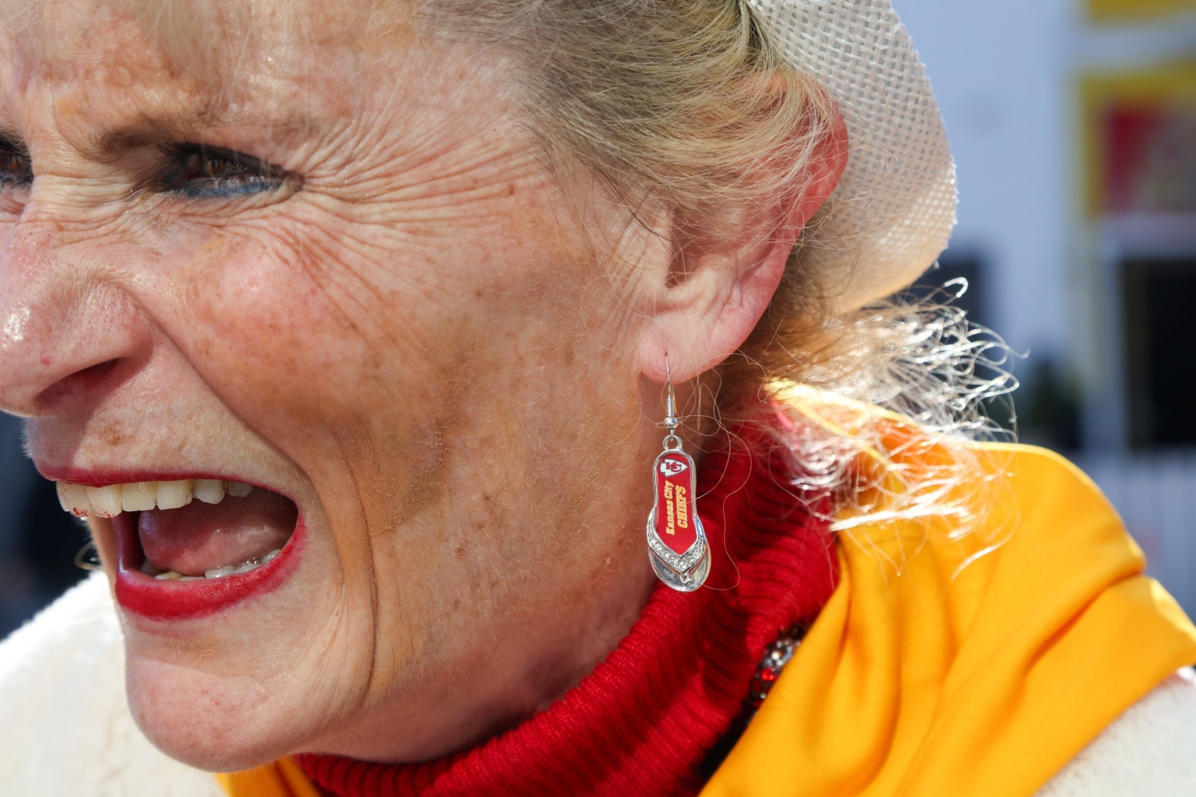 A woman wears Kansas City Chiefs earrings