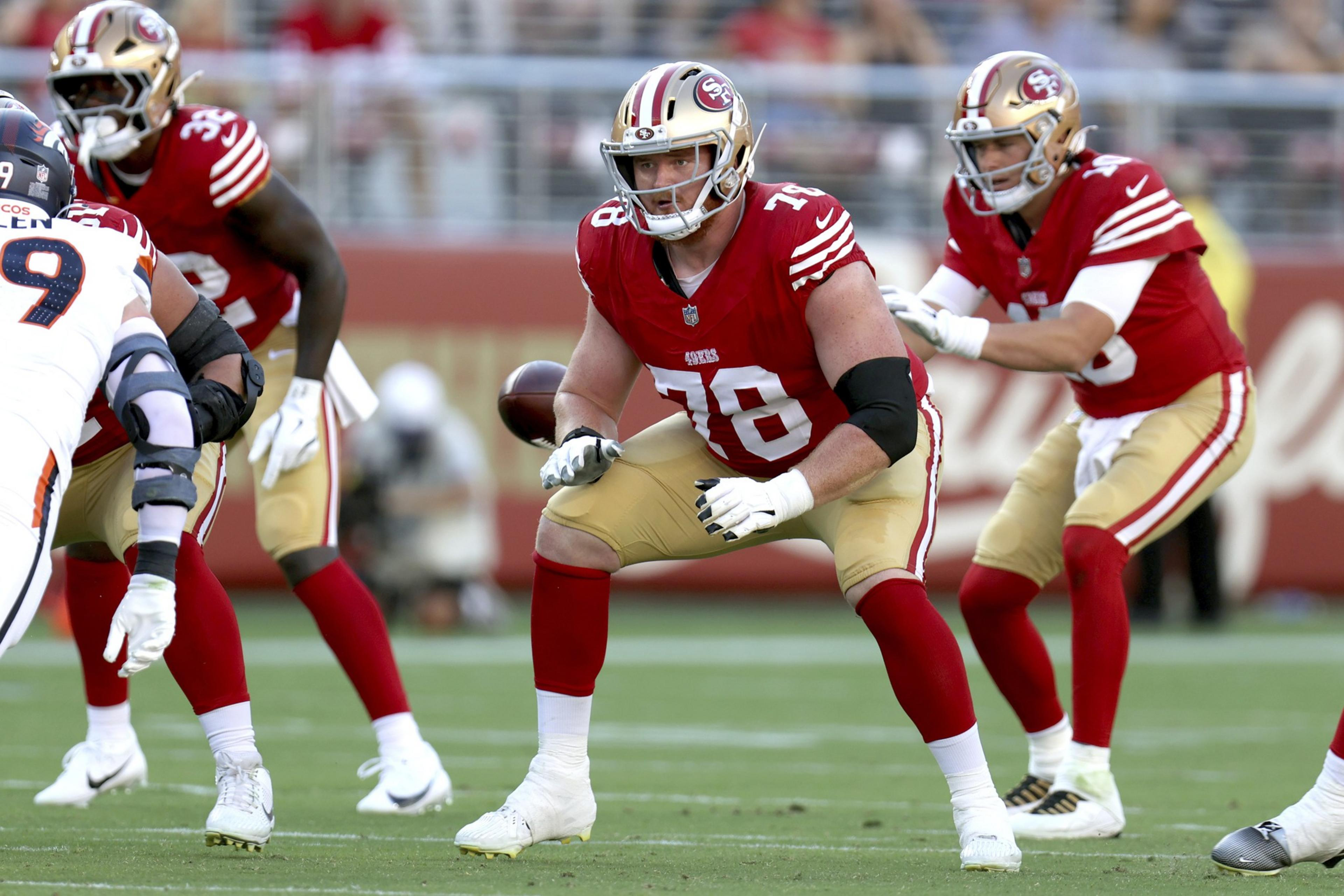 A San Francisco 49ers player wearing number 78 braces in a blocking stance as the quarterback prepares to receive the football during a game.
