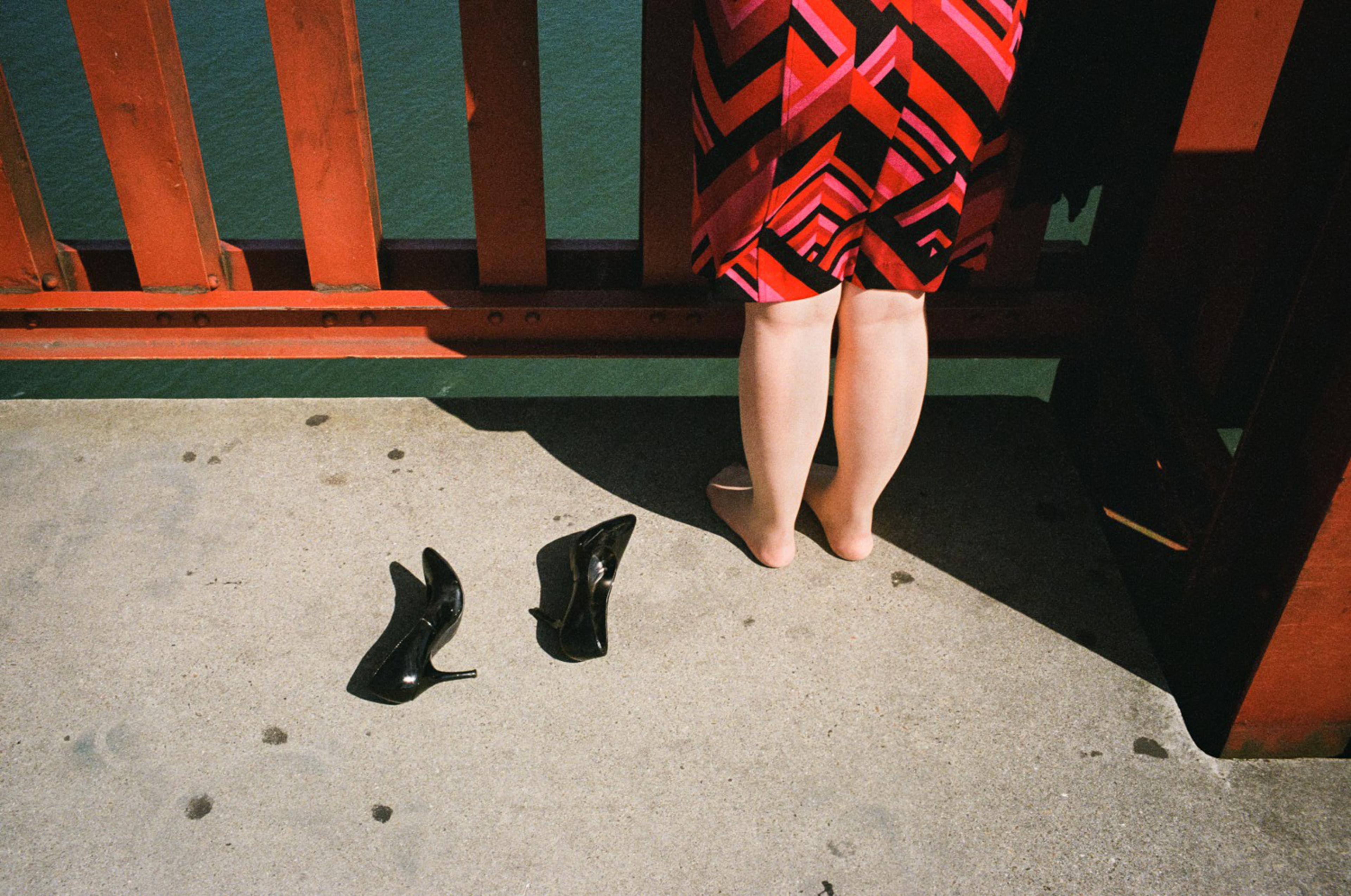 A woman rests her feet after walking across the bridge in high heels in August 2019.