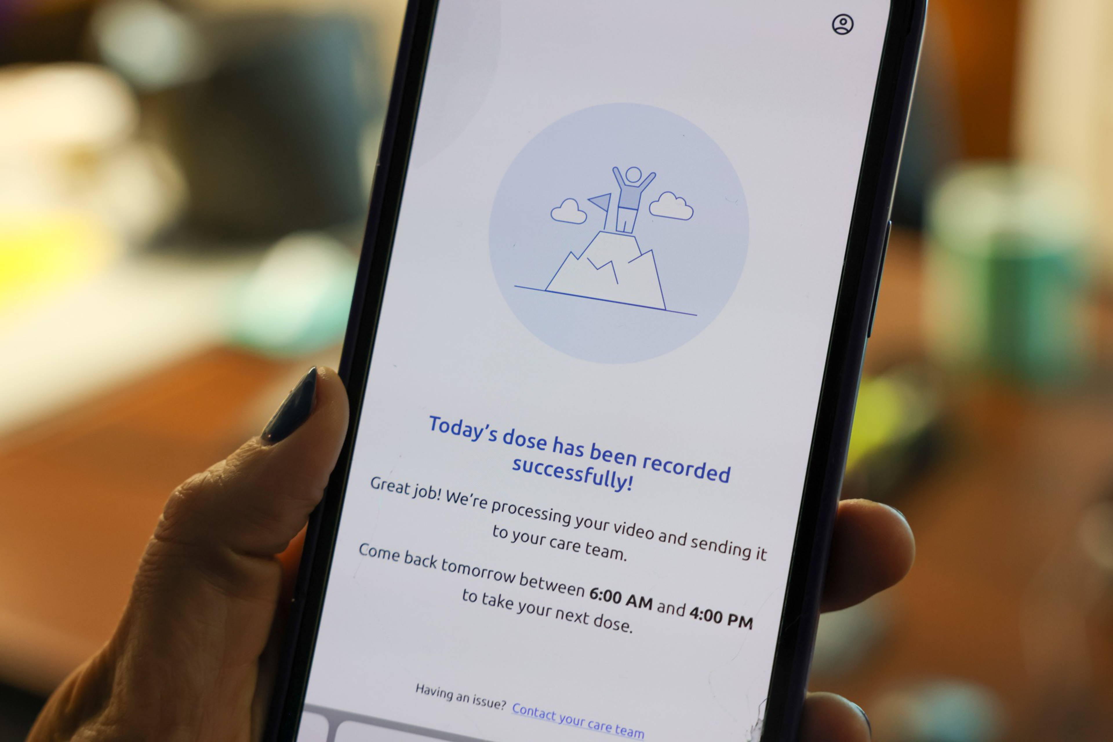A phone screen shows a message confirming today's dose was recorded, with instructions to return between 6:00 AM and 4:00 PM for the next dose.
