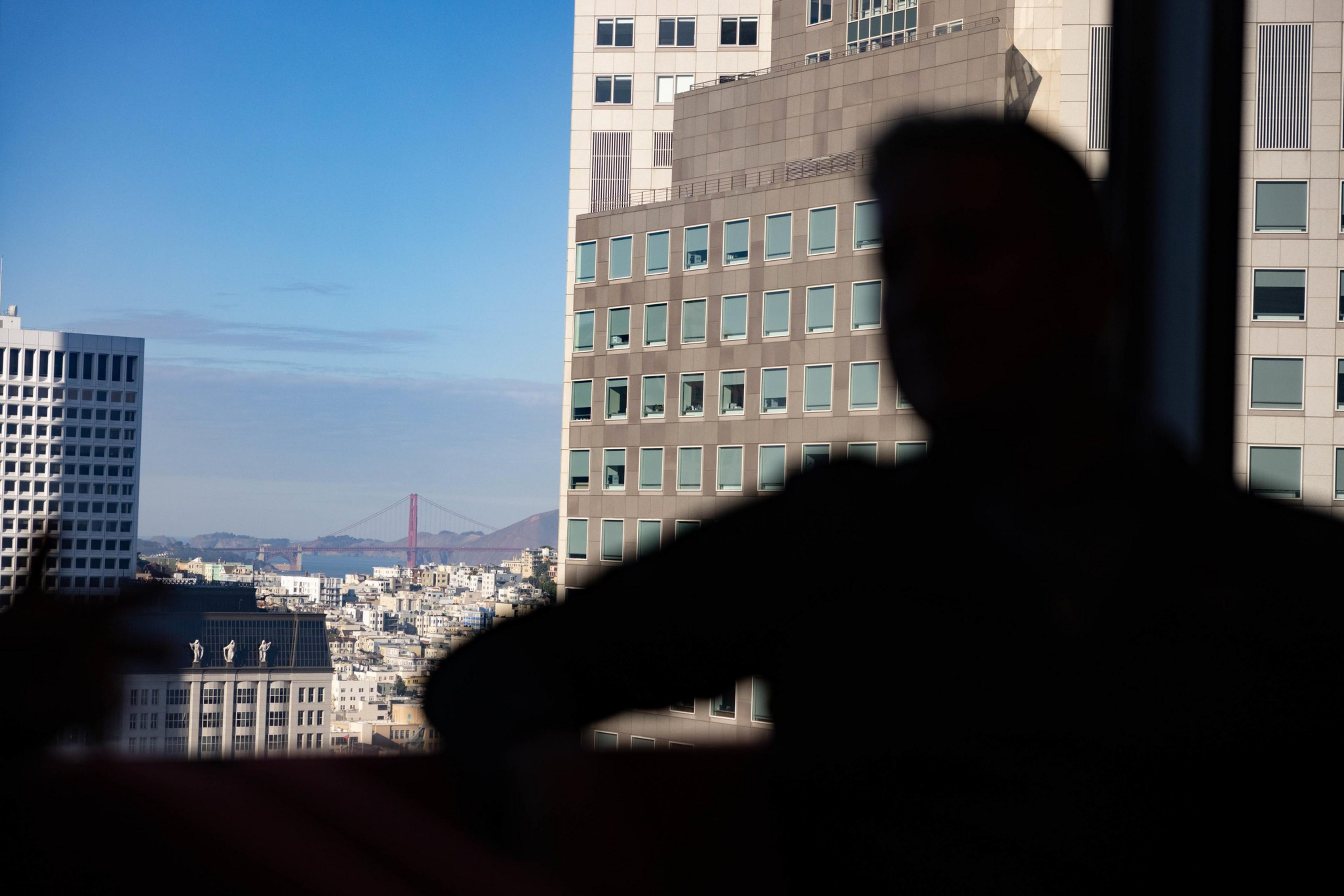 Joe D’ Alessandro sits and in the background you is the buildings and the Golden Gate Bridge.