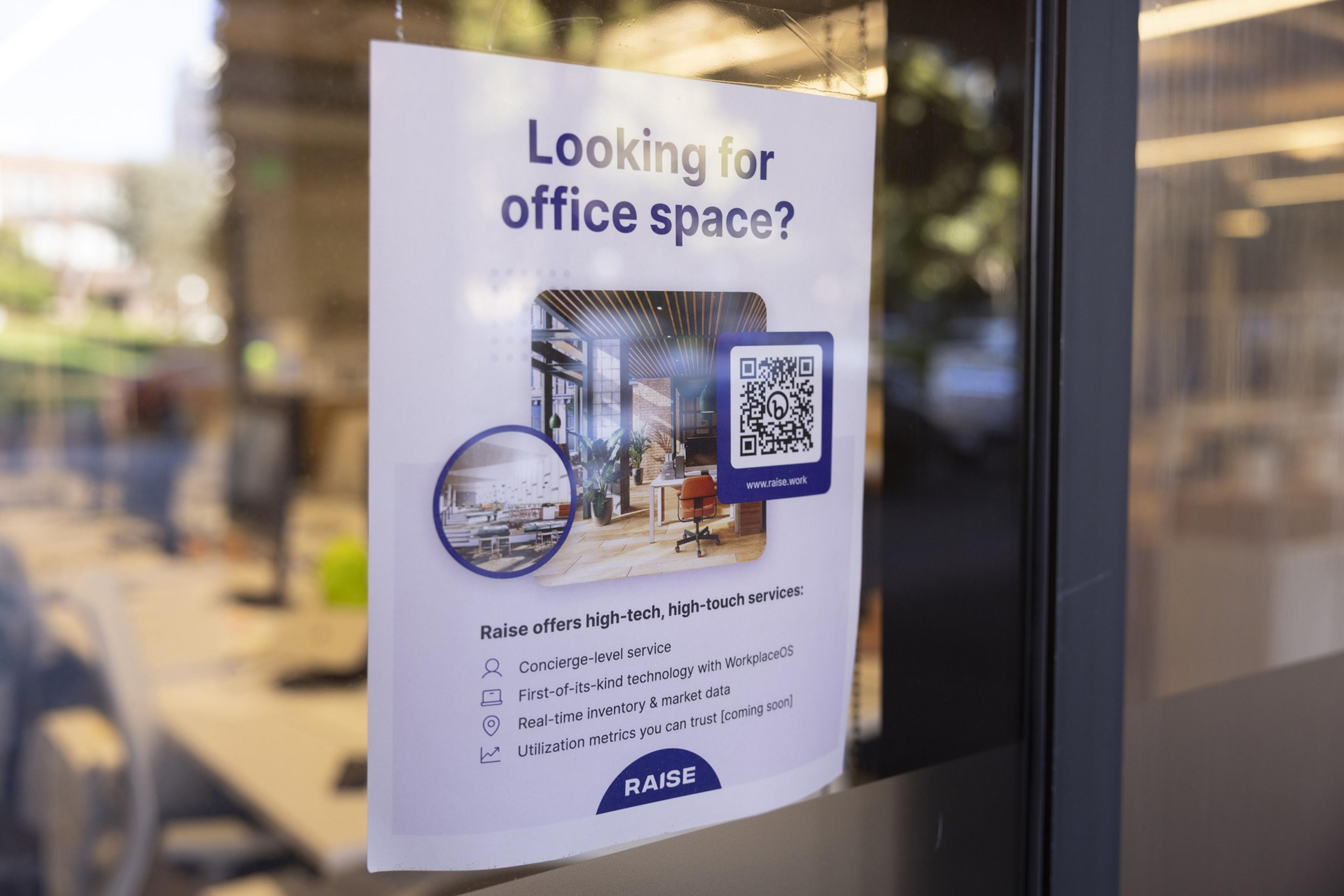 A poster on a glass door advertises office space, featuring photos of modern interiors and a QR code, with highlights of high-tech services offered by Raise.