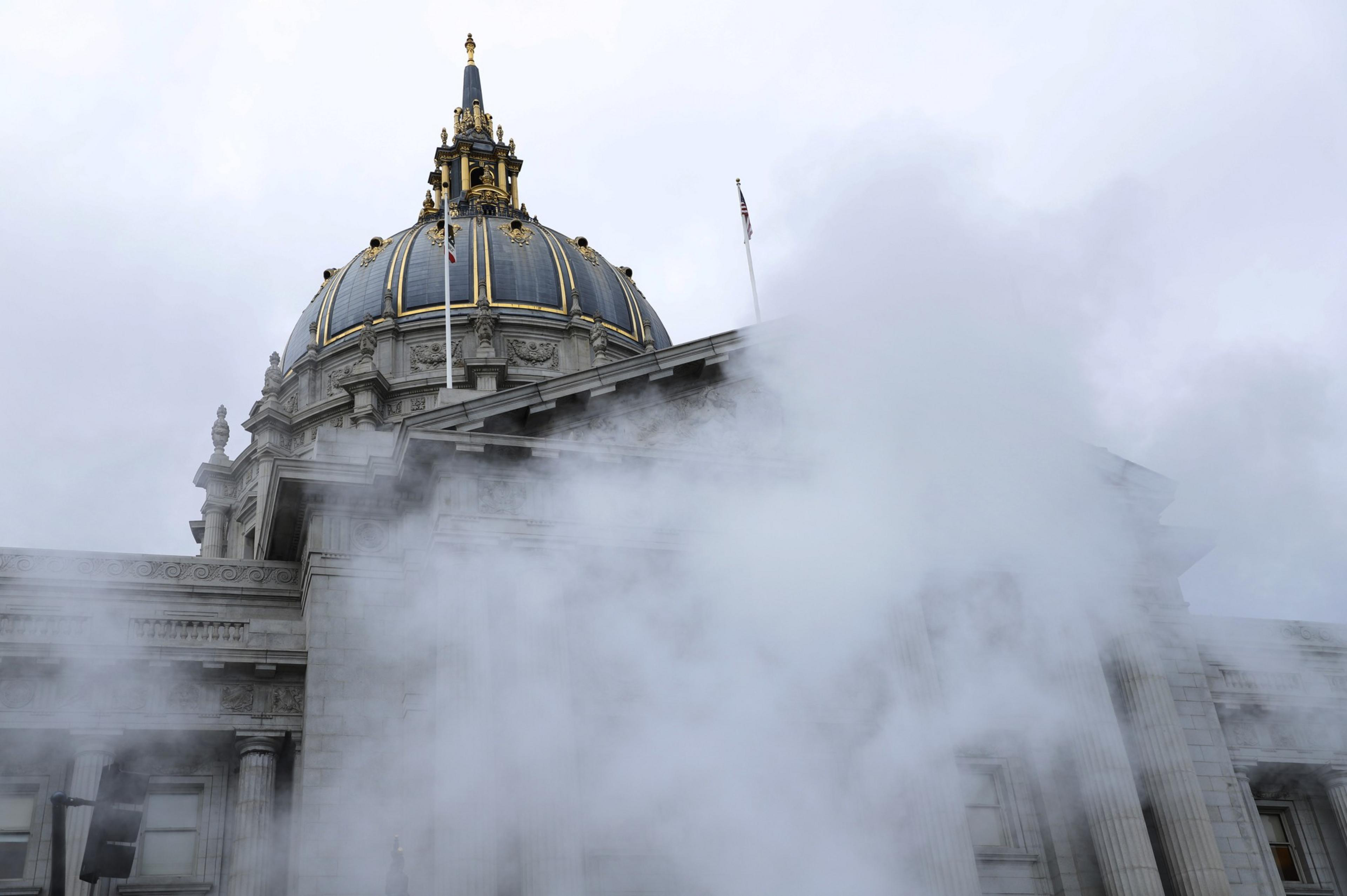 Steam rises from the bottom of the photo with San Francisco's City Hall in the background