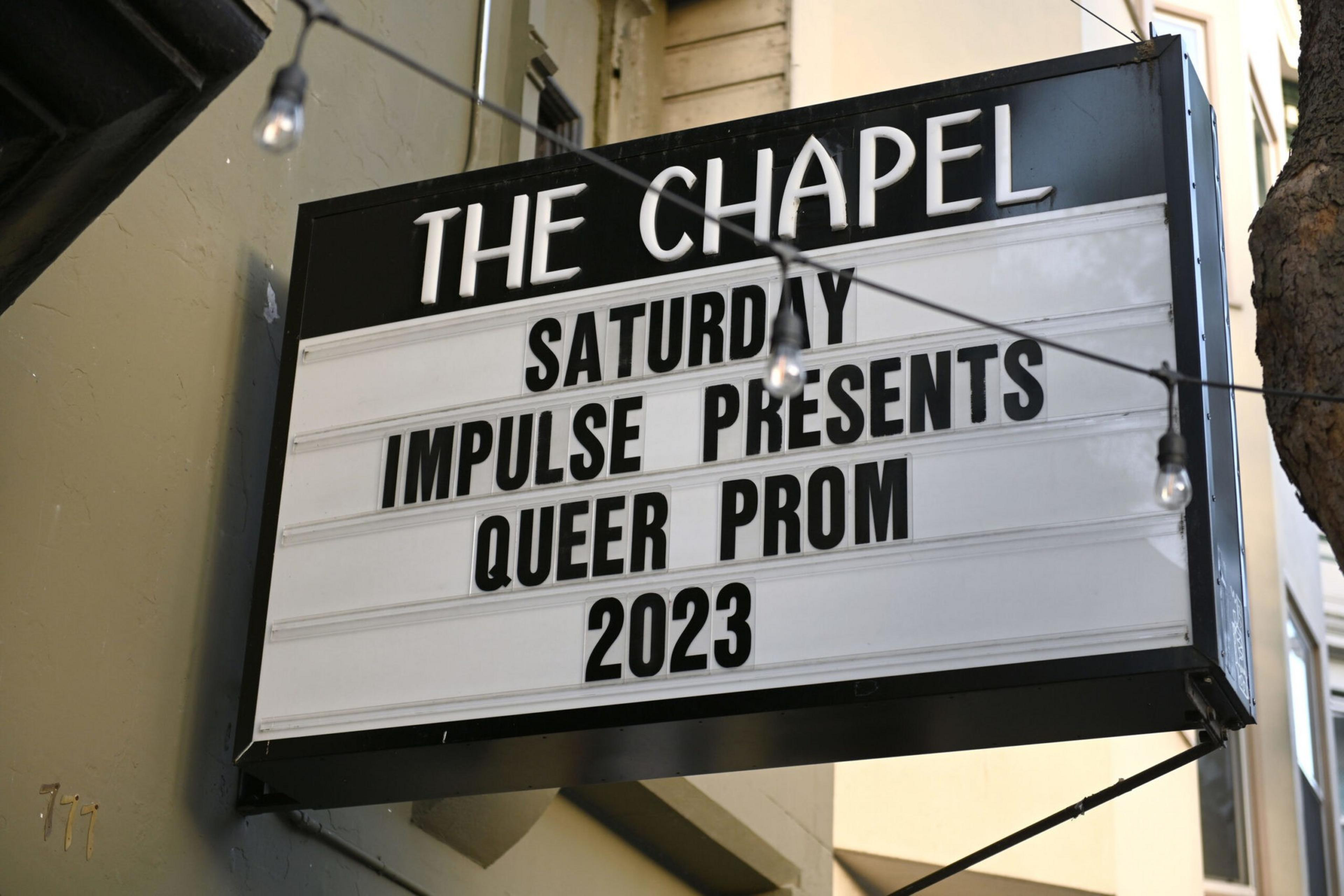 A marquee outside "The Chapel" announces "Saturday Impulse Presents Queer Prom 2023" with string lights hanging in front.