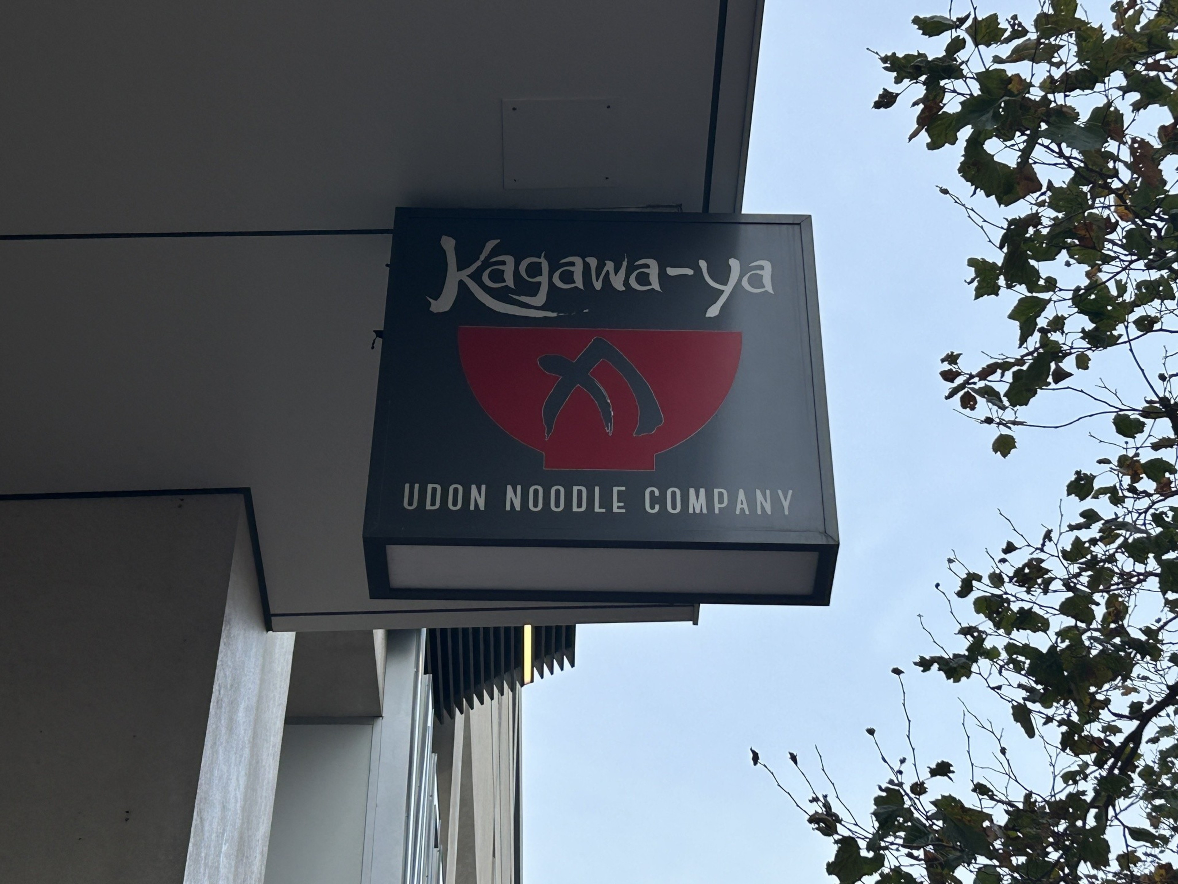 an exterior business sign hangs from an eave
