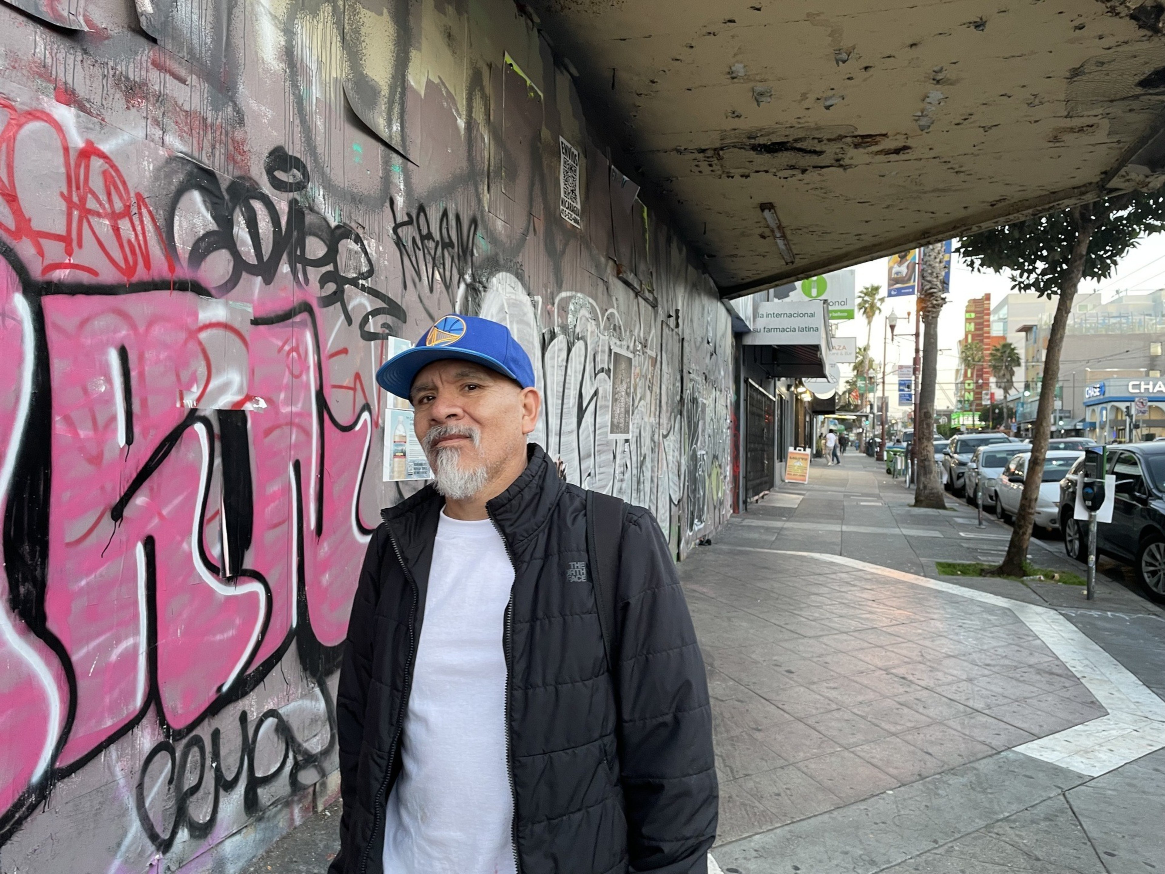A man stands in front of a ruined theater.