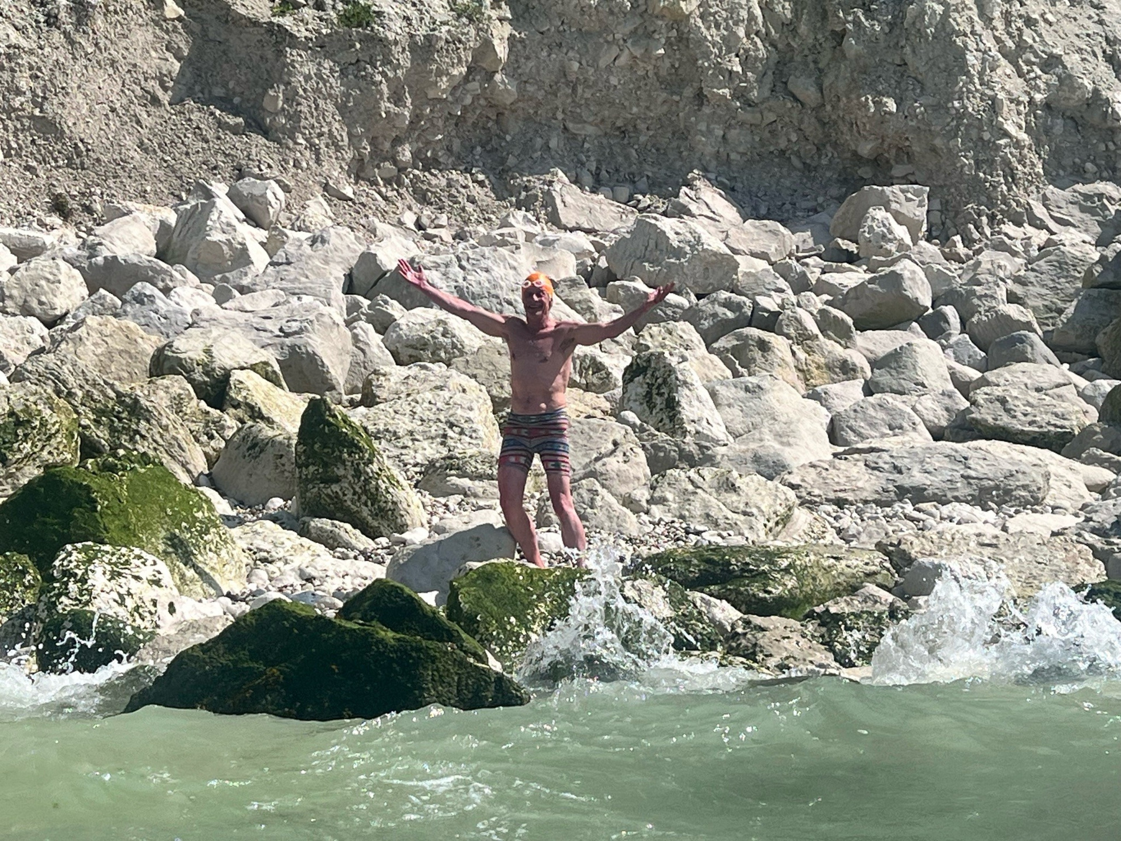 Julian Saperstein, 73, of San Francisco, celebrates after clambering out of the water Wednesday, August 16, 2023 onto the rocky shores of Calais, France. | Courtesy San Francisco Dolphin Club