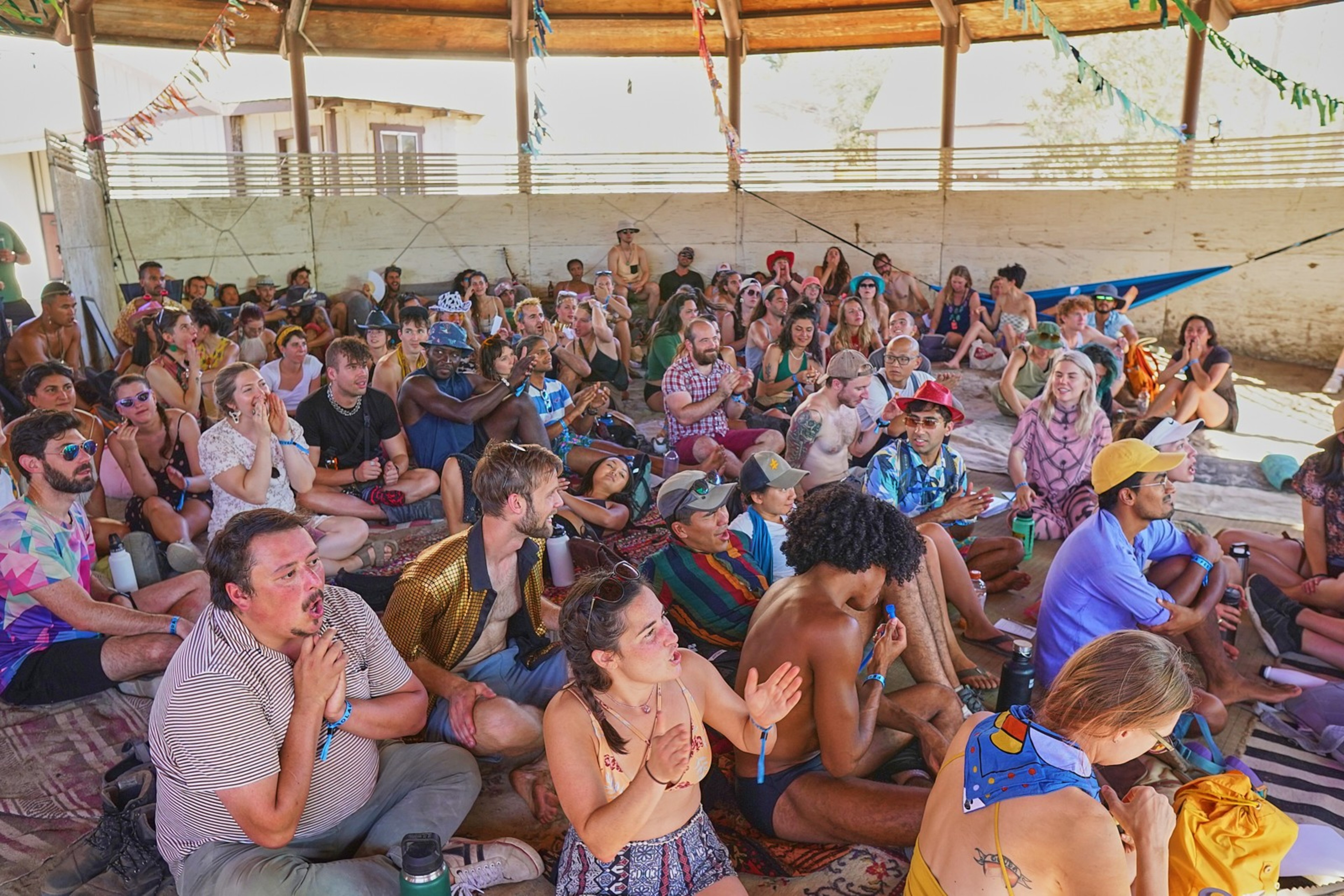A crowd of music festival-goers clap and shout during a live dating show at the Solaura Festival in Mendocino County. 