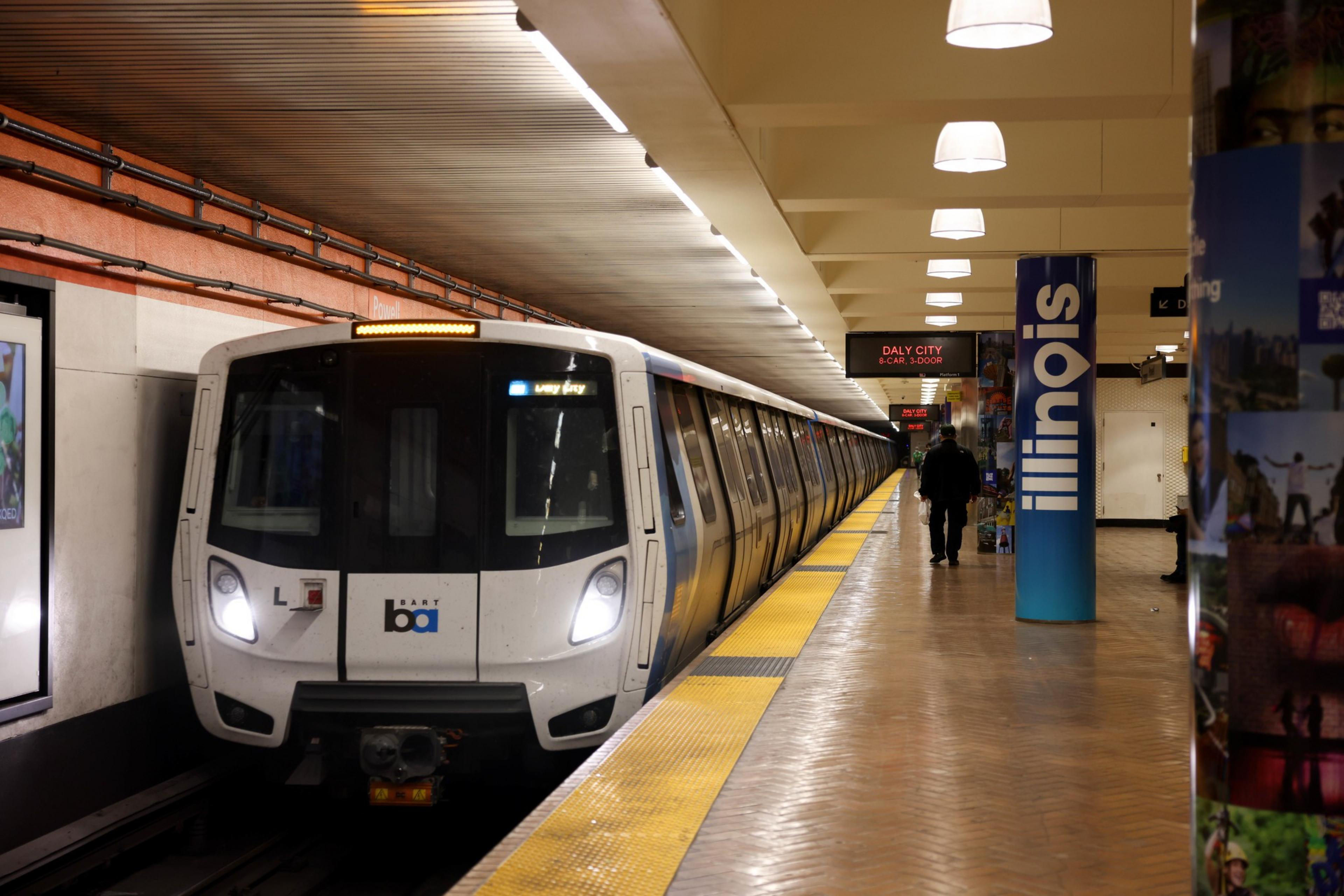 A subway train pulls into an underground station.