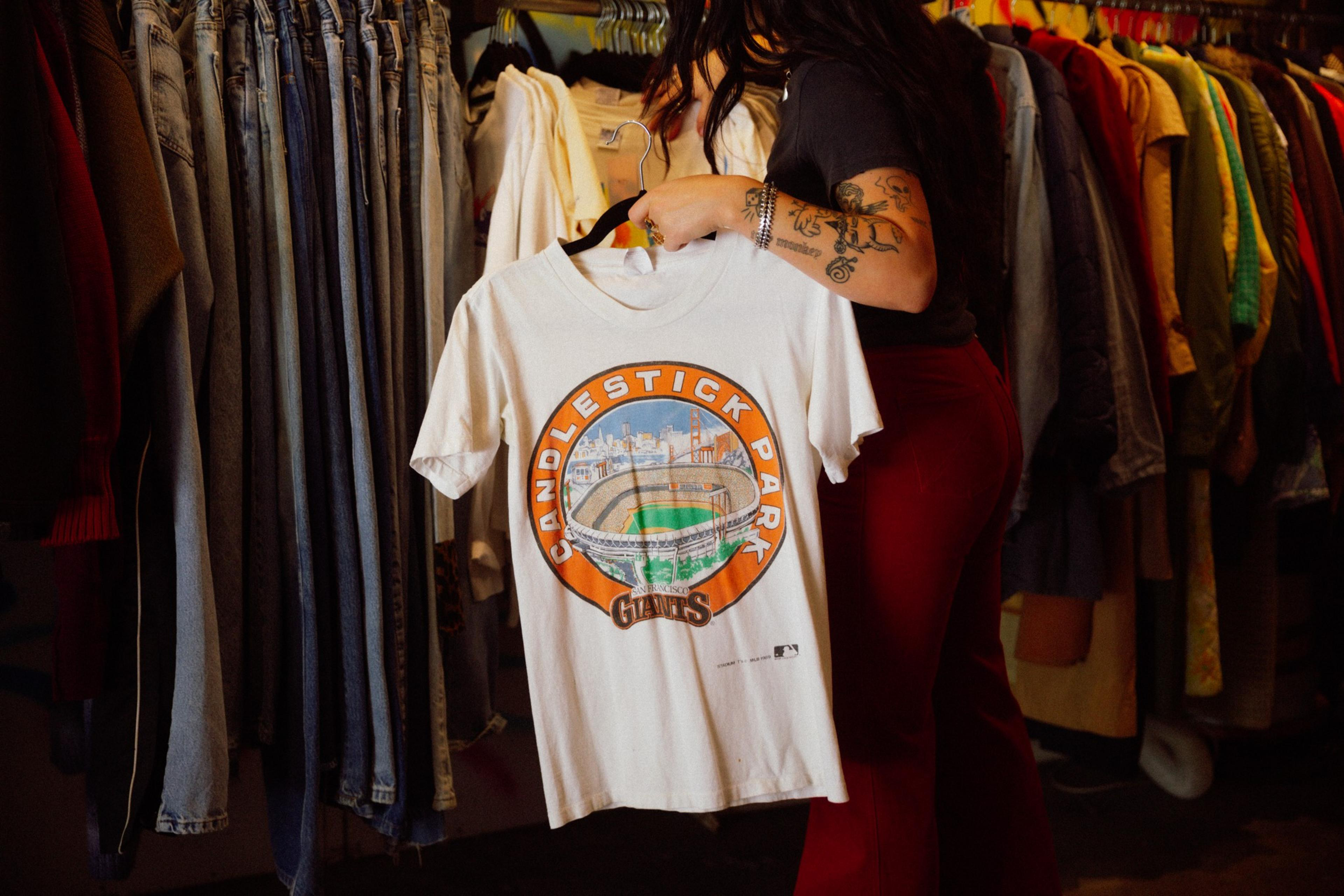Sensitive Vintage proprietor Sivan Peleg holds a retro Giants Candlestick Park graphic T-shirt.