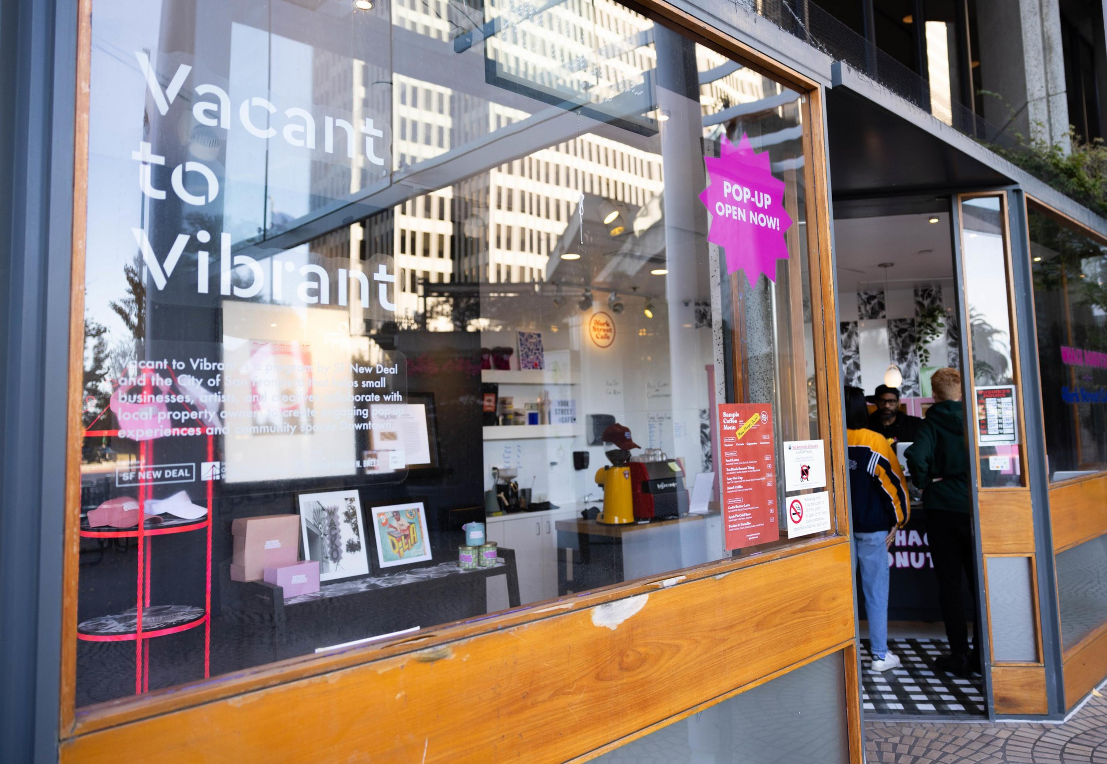 A photo of a business with the words &quot;vacant to vibrant&quot; and &quot;pop-up, open now&quot; on teh exterior.